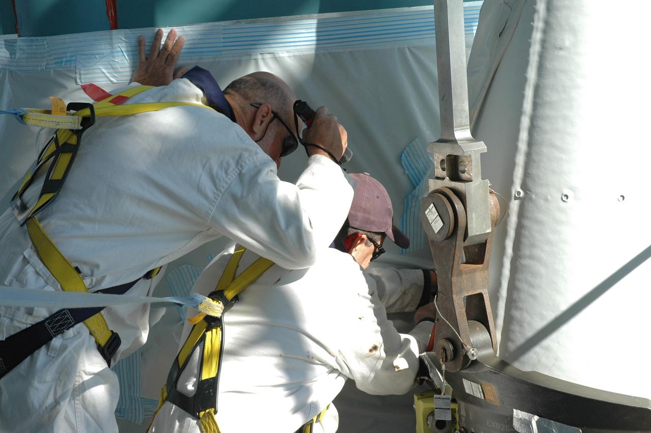 CAPE CANAVERAL, Fla. – On Launch Pad 17-B at Cape Canaveral Air Force Station in Florida, workers make adjustments on one of the solid rocket boosters being mated to the first stage of the Delta 2 launch vehicle that will carry the Kepler spacecraft into orbit. The Kepler mission is specifically designed to survey our region of the Milky Way galaxy to discover hundreds of Earth-size and smaller planets in or near the habitable zone and determine how many of the billions of stars in our galaxy have such planets. Results from this mission will allow us to place our solar system within the continuum of planetary systems in the Galaxy. NASA's planet-hunting Kepler mission is scheduled to launch no earlier than March 5, 2009. Photo credit: NASA/Jim Grossmann