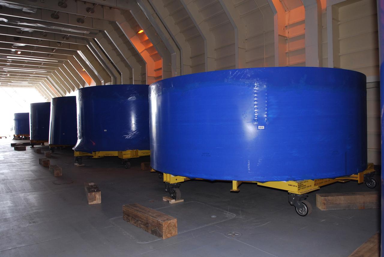 CAPE CANAVERAL, Fla. – Segments of the Ares I-X upper stage simulator are lined up in the cargo hold of the Delta Mariner, docked at Port Canaveral, Fla. The upper stage simulator will be used in the test flight identified as Ares I-X in 2009. The segments will simulate the mass and the outer mold line and will be more than 100 feet of the total vehicle height of 327 feet. The simulator comprises 11 segments that are approximately 18 feet in diameter. Most of the segments will be approximately 10 feet high, ranging in weight from 18,000 to 60,000 pounds, for a total of approximately 450,000 pounds. Photo credit: NASA/Dimitri Gerondidakis