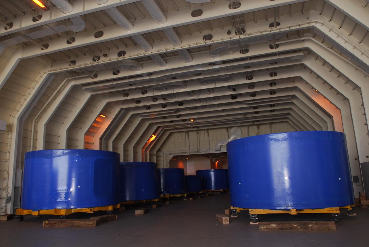 CAPE CANAVERAL, Fla. –  Segments of the Ares I-X upper stage simulator are lined up in the cargo hold of the Delta Mariner, docked at Port Canaveral, Fla. The upper stage simulator will be used in the test flight identified as Ares I-X in 2009.  The segments will simulate the mass and the outer mold line and will be more than 100 feet of the total vehicle height of 327 feet.  The simulator comprises 11 segments that are approximately 18 feet in diameter.  Most of the segments will be approximately 10 feet high, ranging in weight from 18,000 to 60,000 pounds, for a total of approximately 450,000 pounds.  Photo credit: NASA/Dimitri Gerondidakis