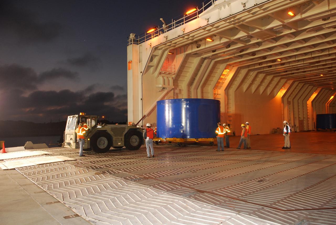CAPE CANAVERAL, Fla. – At Port Canaveral, Fla., one of the Ares I-X upper stage simulator segments is offloaded from the Delta Mariner. The segment will be placed on a flatbed truck for transportation to the Vehicle Assembly Building's high bay 4 at NASA's Kennedy Space Center in Florida. The upper stage simulator will be used in the test flight identified as Ares I-X in 2009. The Ares I-X test flight will provide NASA an early opportunity to test and prove hardware, facilities and ground operations associated with the Ares I crew launch vehicle. It also will allow NASA to gather critical data during ascent of the integrated Orion crew exploration vehicle and the Ares I rocket. The data will ensure the entire vehicle system is safe and fully operational before astronauts begin traveling to orbit. The simulator segments will simulate the mass and the outer mold line and will be more than 100 feet of the total vehicle height of 327 feet. The simulator comprises 11 segments that are approximately 18 feet in diameter. Most of the segments will be approximately 10 feet high, ranging in weight from 18,000 to 60,000 pounds, for a total of approximately 450,000 pounds. Photo credit: NASA/Cory Huston
