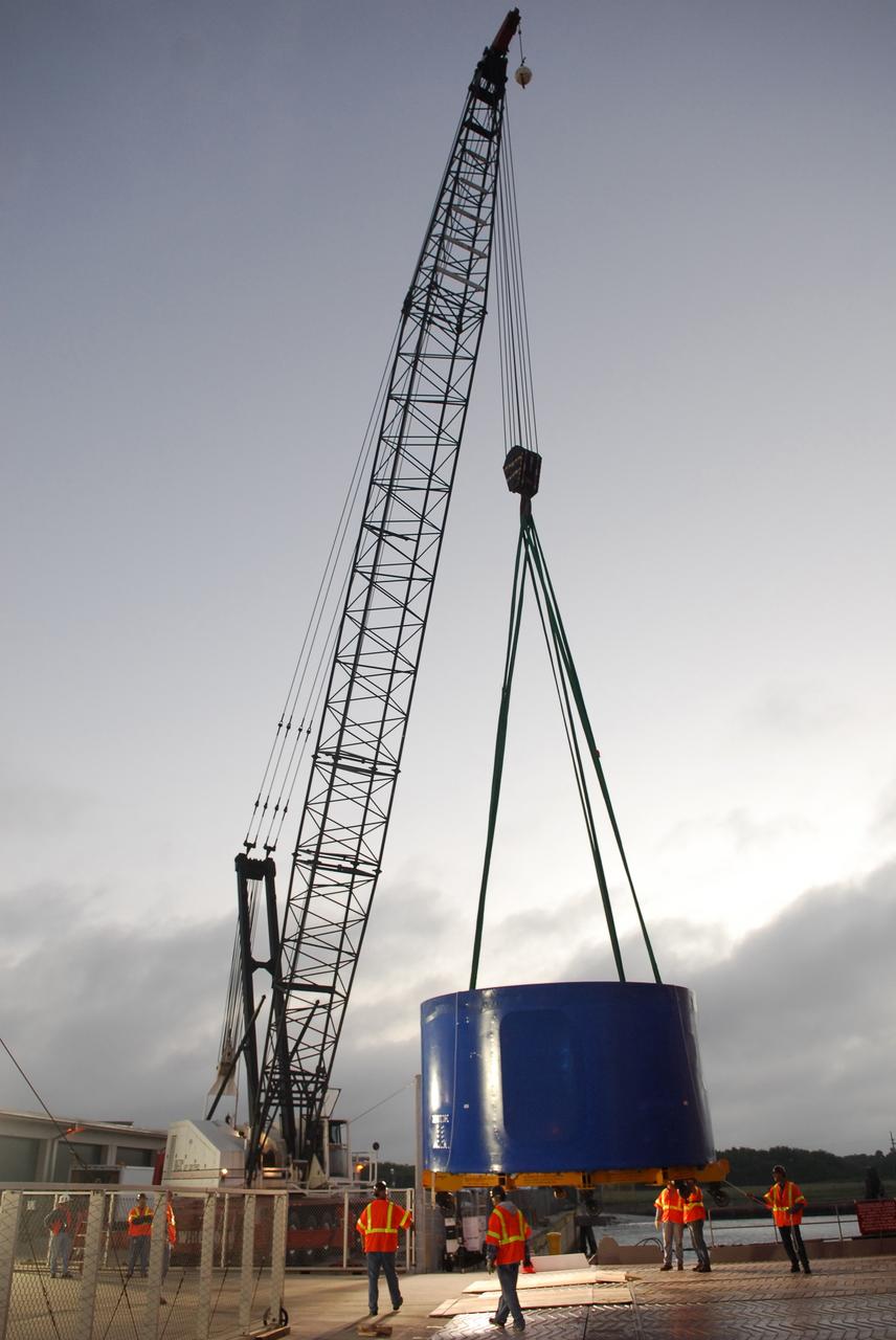 CAPE CANAVERAL, Fla. – A crane lifts and transfers an Ares I-X upper stage simulator segment from the Delta Mariner at Port Canaveral, Fla., onto a flatbed truck. They will be transported to the Vehicle Assembly Building's high bay 4 at NASA's Kennedy Space Center in Florida. The upper stage simulator will be used in the test flight identified as Ares I-X in 2009. The Ares I-X test flight will provide NASA an early opportunity to test and prove hardware, facilities and ground operations associated with the Ares I crew launch vehicle. It also will allow NASA to gather critical data during ascent of the integrated Orion crew exploration vehicle and the Ares I rocket. The data will ensure the entire vehicle system is safe and fully operational before astronauts begin traveling to orbit. The simulator segments will simulate the mass and the outer mold line and will be more than 100 feet of the total vehicle height of 327 feet. The simulator comprises 11 segments that are approximately 18 feet in diameter. Most of the segments will be approximately 10 feet high, ranging in weight from 18,000 to 60,000 pounds, for a total of approximately 450,000 pounds. Photo credit: NASA/Cory Huston