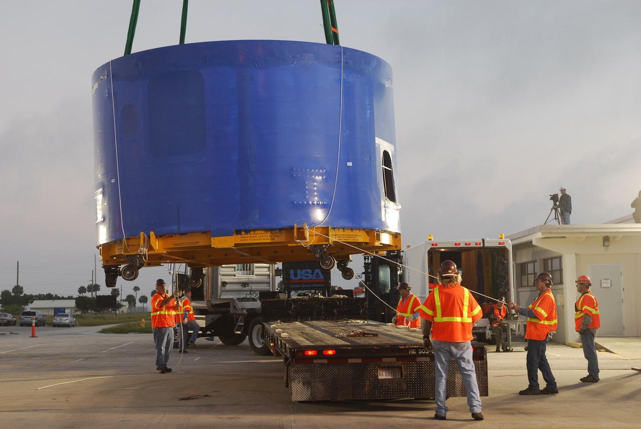 CAPE CANAVERAL, Fla. – A crane lifts and transfers an Ares I-X upper stage simulator segment from the Delta Mariner at Port Canaveral, Fla., onto a flatbed truck. They will be transported to the Vehicle Assembly Building's high bay 4 at NASA's Kennedy Space Center in Florida. The upper stage simulator will be used in the test flight identified as Ares I-X in 2009. The Ares I-X test flight will provide NASA an early opportunity to test and prove hardware, facilities and ground operations associated with the Ares I crew launch vehicle. It also will allow NASA to gather critical data during ascent of the integrated Orion crew exploration vehicle and the Ares I rocket. The data will ensure the entire vehicle system is safe and fully operational before astronauts begin traveling to orbit. The simulator segments will simulate the mass and the outer mold line and will be more than 100 feet of the total vehicle height of 327 feet. The simulator comprises 11 segments that are approximately 18 feet in diameter. Most of the segments will be approximately 10 feet high, ranging in weight from 18,000 to 60,000 pounds, for a total of approximately 450,000 pounds. Photo credit: NASA/Cory Huston