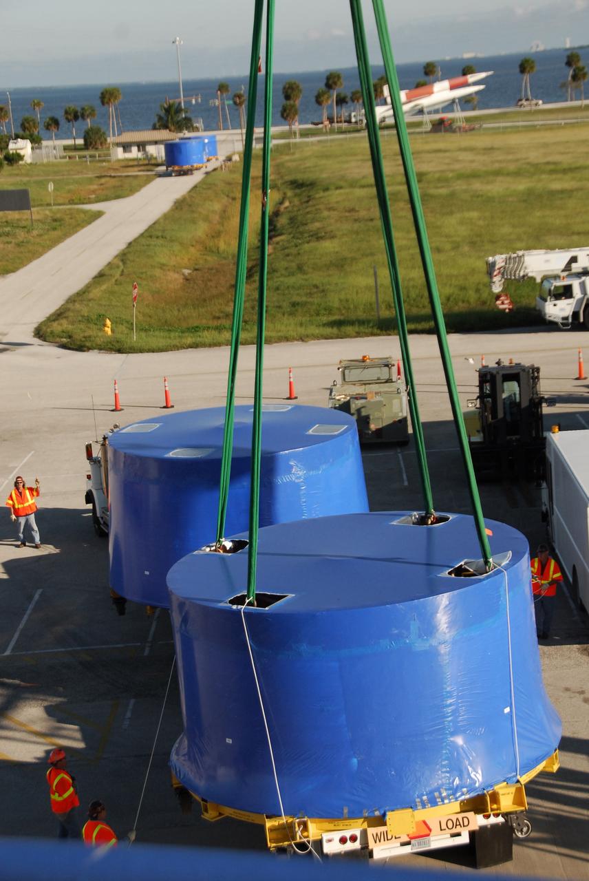 CAPE CANAVERAL, Fla. – A crane lifts and transfers Ares I-X upper stage simulator segments from the Delta Mariner at Port Canaveral, Fla., onto a flatbed truck. They will be transported to the Vehicle Assembly Building's high bay 4 at NASA's Kennedy Space Center in Florida. The upper stage simulator will be used in the test flight identified as Ares I-X in 2009. The Ares I-X test flight will provide NASA an early opportunity to test and prove hardware, facilities and ground operations associated with the Ares I crew launch vehicle. It also will allow NASA to gather critical data during ascent of the integrated Orion crew exploration vehicle and the Ares I rocket. The data will ensure the entire vehicle system is safe and fully operational before astronauts begin traveling to orbit. The simulator segments will simulate the mass and the outer mold line and will be more than 100 feet of the total vehicle height of 327 feet. The simulator comprises 11 segments that are approximately 18 feet in diameter. Most of the segments will be approximately 10 feet high, ranging in weight from 18,000 to 60,000 pounds, for a total of approximately 450,000 pounds. Photo credit: NASA/Cory Huston