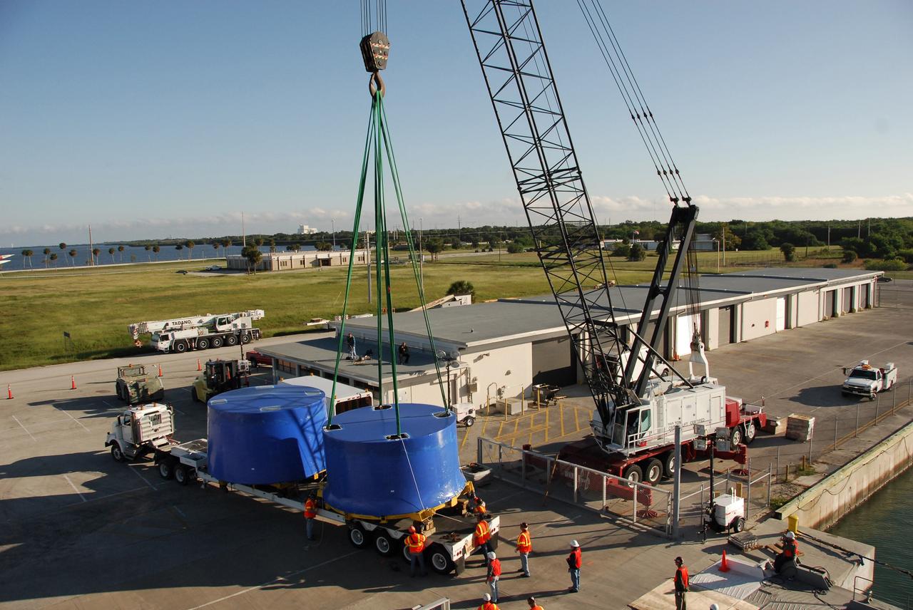 CAPE CANAVERAL, Fla. – A crane lifts and transfers Ares I-X upper stage simulator segments from the Delta Mariner at Port Canaveral, Fla., onto a flatbed truck. They will be transported to the Vehicle Assembly Building's high bay 4 at NASA's Kennedy Space Center in Florida. The upper stage simulator will be used in the test flight identified as Ares I-X in 2009. The Ares I-X test flight will provide NASA an early opportunity to test and prove hardware, facilities and ground operations associated with the Ares I crew launch vehicle. It also will allow NASA to gather critical data during ascent of the integrated Orion crew exploration vehicle and the Ares I rocket. The data will ensure the entire vehicle system is safe and fully operational before astronauts begin traveling to orbit. The simulator segments will simulate the mass and the outer mold line and will be more than 100 feet of the total vehicle height of 327 feet. The simulator comprises 11 segments that are approximately 18 feet in diameter. Most of the segments will be approximately 10 feet high, ranging in weight from 18,000 to 60,000 pounds, for a total of approximately 450,000 pounds. Photo credit: NASA/Cory Huston