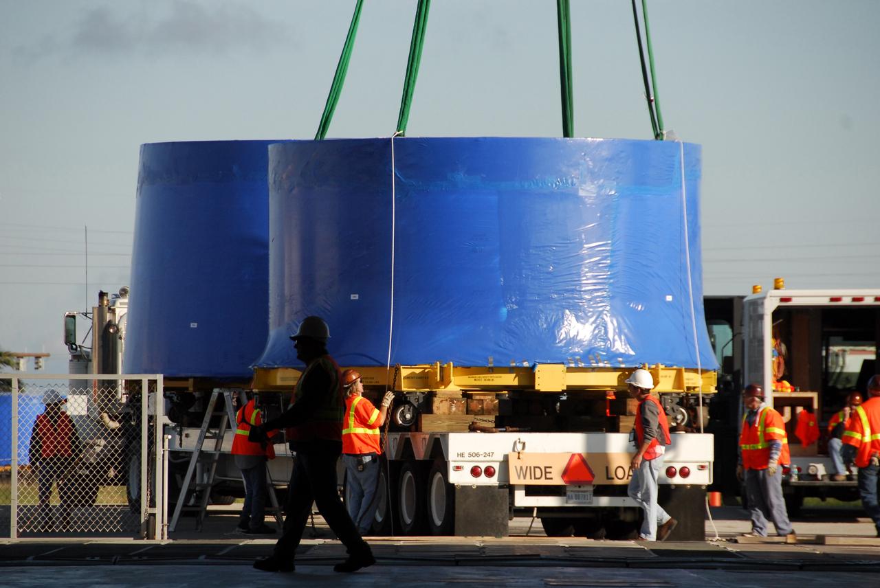 CAPE CANAVERAL, Fla. – A crane lifts and transfers an Ares I-X upper stage simulator segment from the Delta Mariner at Port Canaveral, Fla., onto a flatbed truck. They will be transported to the Vehicle Assembly Building's high bay 4 at NASA's Kennedy Space Center in Florida. The upper stage simulators will be used in the test flight identified as Ares I-X in 2009. The Ares I-X test flight will provide NASA an early opportunity to test and prove hardware, facilities and ground operations associated with the Ares I crew launch vehicle. It also will allow NASA to gather critical data during ascent of the integrated Orion crew exploration vehicle and the Ares I rocket. The data will ensure the entire vehicle system is safe and fully operational before astronauts begin traveling to orbit. The simulator segments will simulate the mass and the outer mold line and will be more than 100 feet of the total vehicle height of 327 feet. The simulator comprises 11 segments that are approximately 18 feet in diameter. Most of the segments will be approximately 10 feet high, ranging in weight from 18,000 to 60,000 pounds, for a total of approximately 450,000 pounds. Photo credit: NASA/Cory Huston