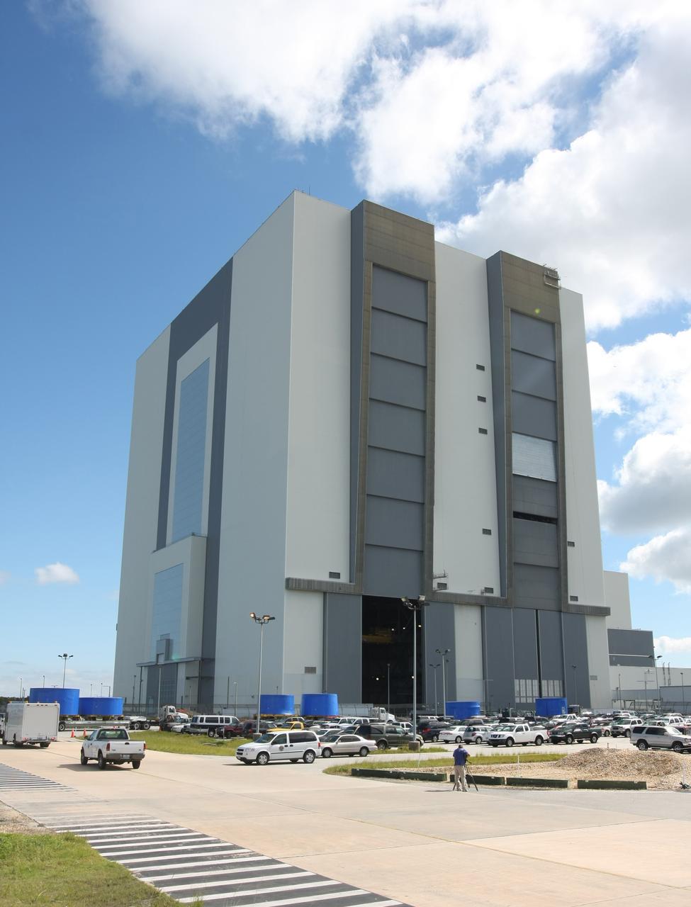 CAPE CANAVERAL, Fla. – Trucks carrying the blue Ares I-X upper stage simulator segments are lined up outside the Vehicle Assembly Building's high bay 4 at NASA's Kennedy Space Center in Florida. The segments will be offloaded inside bay 4. The upper stage simulators will be used in the test flight identified as Ares I-X in 2009. The Ares I-X test flight will provide NASA an early opportunity to test and prove hardware, facilities and ground operations associated with the Ares I crew launch vehicle. It also will allow NASA to gather critical data during ascent of the integrated Orion crew exploration vehicle and the Ares I rocket. The data will ensure the entire vehicle system is safe and fully operational before astronauts begin traveling to orbit. The simulator segments will simulate the mass and the outer mold line and will be more than 100 feet of the total vehicle height of 327 feet. The simulator comprises 11 segments that are approximately 18 feet in diameter. Most of the segments will be approximately 10 feet high, ranging in weight from 18,000 to 60,000 pounds, for a total of approximately 450,000 pounds. Photo credit: NASA/Cory Huston