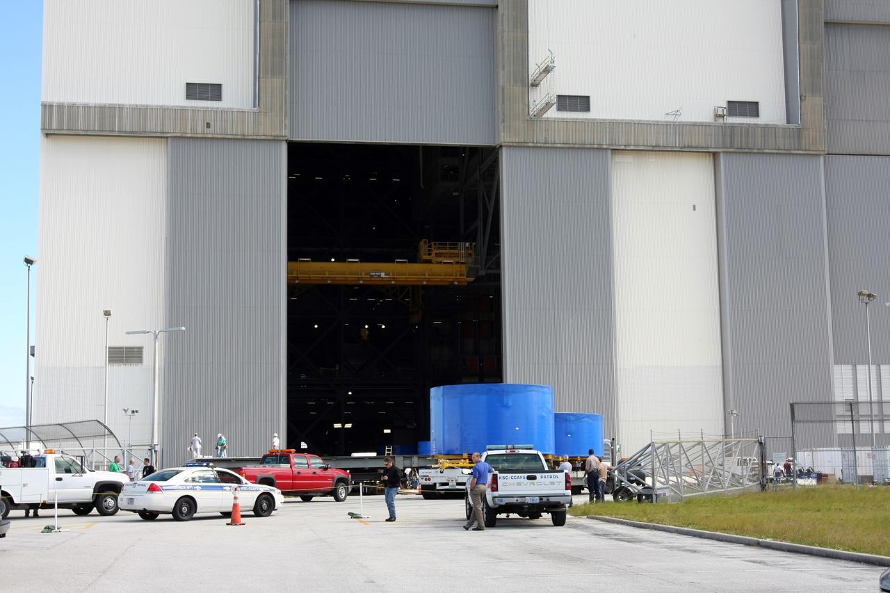 CAPE CANAVERAL, Fla. – Ares I-X upper stage simulator segments arrive at the Vehicle Assembly Building's high bay 4 at NASA's Kennedy Space Center in Florida. The segments will be offloaded inside bay 4. The upper stage simulator will be used in the test flight identified as Ares I-X in 2009. The Ares I-X test flight will provide NASA an early opportunity to test and prove hardware, facilities and ground operations associated with the Ares I crew launch vehicle. It also will allow NASA to gather critical data during ascent of the integrated Orion crew exploration vehicle and the Ares I rocket. The data will ensure the entire vehicle system is safe and fully operational before astronauts begin traveling to orbit. The simulator segments will simulate the mass and the outer mold line and will be more than 100 feet of the total vehicle height of 327 feet. The simulator comprises 11 segments that are approximately 18 feet in diameter. Most of the segments will be approximately 10 feet high, ranging in weight from 18,000 to 60,000 pounds, for a total of approximately 450,000 pounds. Photo credit: NASA/Cory Huston