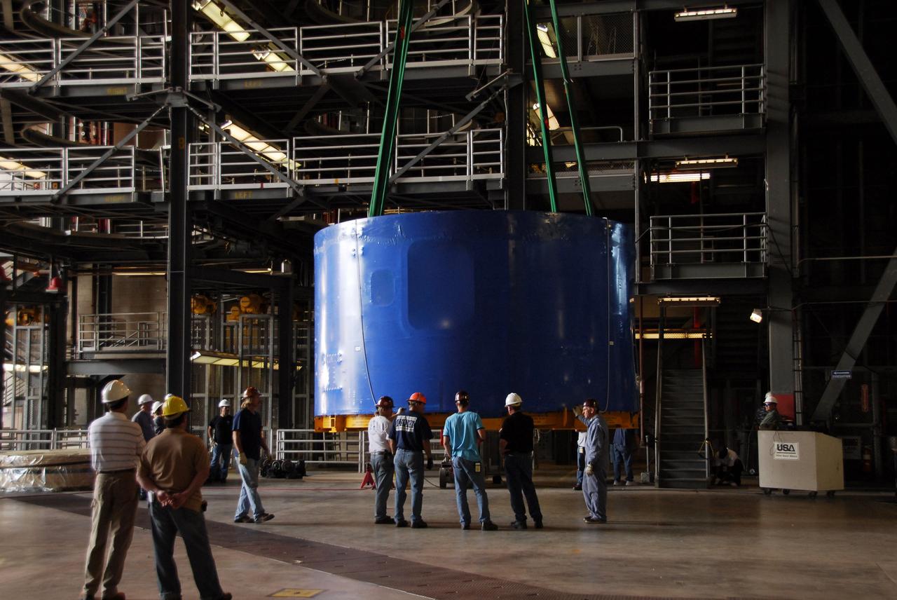 CAPE CANAVERAL, Fla. – Inside the Vehicle Assembly Building's high bay 4 at NASA's Kennedy Space Center in Florida, one of the Ares I-X upper stage simulator segments is offloaded from its transporter and placed on the floor. The segments arrived Nov. 4 at Port Canaveral, Fla., aboard the Delta Mariner. The upper stage simulators will be used in the test flight identified as Ares I-X in 2009. The Ares I-X test flight will provide NASA an early opportunity to test and prove hardware, facilities and ground operations associated with the Ares I crew launch vehicle. It also will allow NASA to gather critical data during ascent of the integrated Orion crew exploration vehicle and the Ares I rocket. The data will ensure the entire vehicle system is safe and fully operational before astronauts begin traveling to orbit. The simulator segments will simulate the mass and the outer mold line and will be more than 100 feet of the total vehicle height of 327 feet. The simulator comprises 11 segments that are approximately 18 feet in diameter. Most of the segments will be approximately 10 feet high, ranging in weight from 18,000 to 60,000 pounds, for a total of approximately 450,000 pounds. Photo credit: NASA/Cory Huston