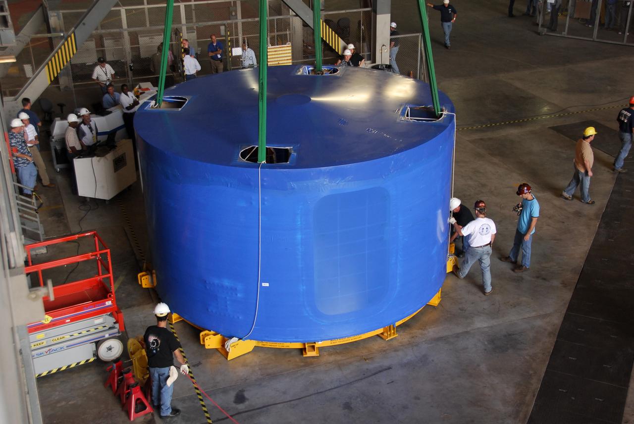 CAPE CANAVERAL, Fla. – Inside the Vehicle Assembly Building's high bay 4 at NASA's Kennedy Space Center in Florida, one of the Ares I-X upper stage simulator segments is offloaded from its transporter and placed on the floor. The segments arrived Nov. 4 at Port Canaveral, Fla., aboard the Delta Mariner. The upper stage simulators will be used in the test flight identified as Ares I-X in 2009. The Ares I-X test flight will provide NASA an early opportunity to test and prove hardware, facilities and ground operations associated with the Ares I crew launch vehicle. It also will allow NASA to gather critical data during ascent of the integrated Orion crew exploration vehicle and the Ares I rocket. The data will ensure the entire vehicle system is safe and fully operational before astronauts begin traveling to orbit. The simulator segments will simulate the mass and the outer mold line and will be more than 100 feet of the total vehicle height of 327 feet. The simulator comprises 11 segments that are approximately 18 feet in diameter. Most of the segments will be approximately 10 feet high, ranging in weight from 18,000 to 60,000 pounds, for a total of approximately 450,000 pounds. Photo credit: NASA/Cory Huston