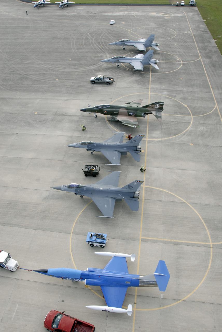 CAPE CANAVERAL, Fla. – Military aircraft are lined up on the Shuttle Landing Facility at NASA's Kennedy Space Center in Florida.  The F/A-18s, F-4, F-16 and F-104G Starfighter will take part in demonstrations at the Kennedy Space Center Visitor Complex Space and Air Show Nov. 8-9.  The Navy's elite flight demonstration squadron, the Blue Angels, will take to the skies in military aircraft demonstrations for the second annual Space & Air Show at Kennedy. This year’s show brings together the best in military aircraft, coupled with precision pilots and veteran astronauts to celebrate spaceflight and aviation. The event also includes demonstrations by the F-16 Fighting Falcon and a water rescue demonstration by the 920th Rescue Wing.  Photo credit: NASA/Kim Shiflett
