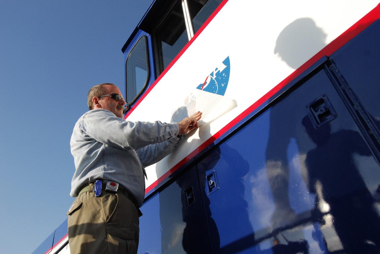 CAPE CANAVERAL, Fla. – At NASA's Kennedy Space Center in Florida, Phil Moore places a new NASA insignia on the side of NASA Railroad locomotive 3. The Railroad Operation and Maintenance Team at Kennedy completed the refurbishment of locomotive 3 in October. The 15-month process, including a new paint scheme, dealt with extensive corrosion to the locomotive because of Kennedy's proximity to the Atlantic Ocean. Locomotives 1 and 2 also will be refurbished eventually. The NASA Railroad locomotives are SW-1500 switch engines built by Electro Motive Diesel (EMD). Photo credit: NASA/Amanda Diller