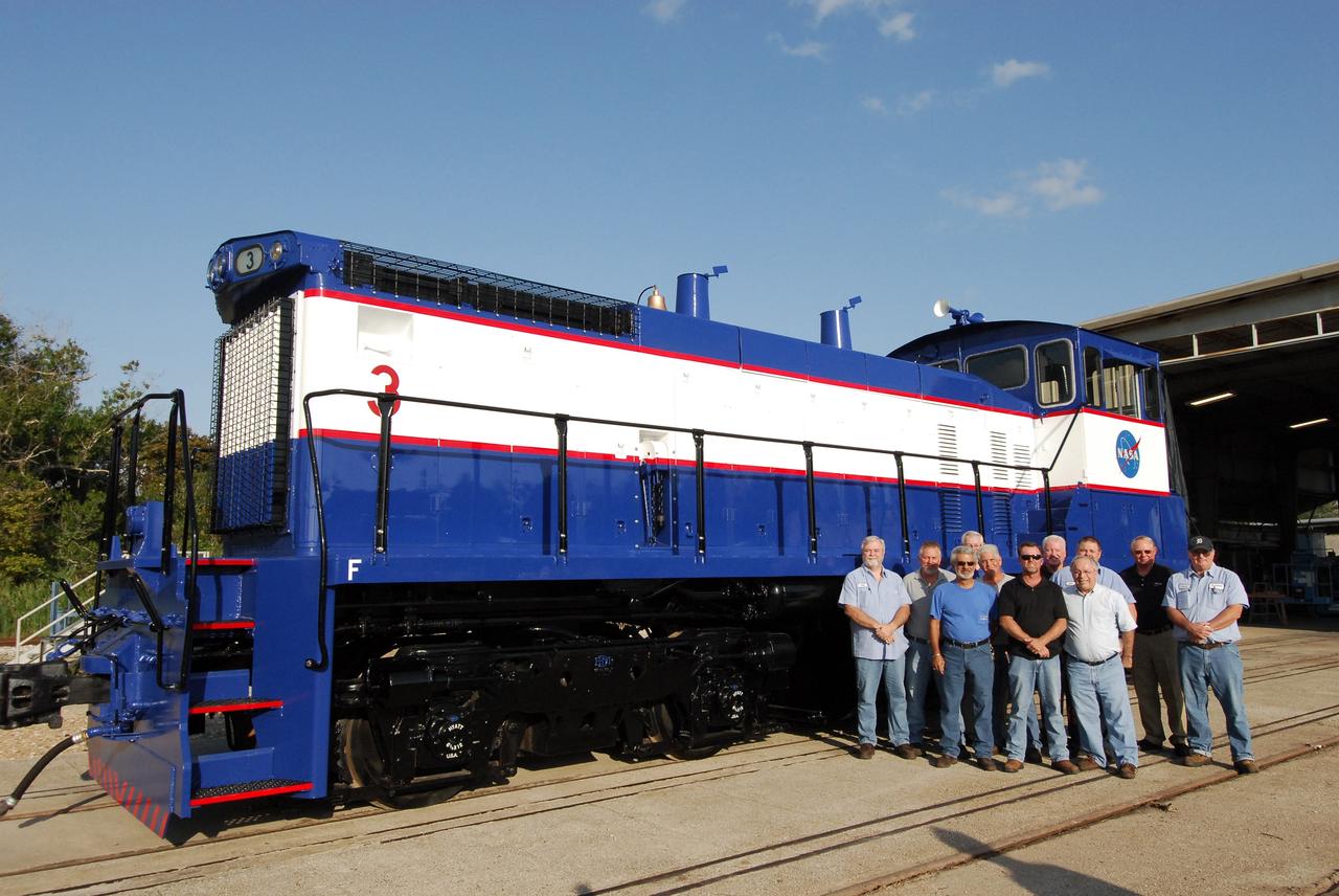 CAPE CANAVERAL, Fla. – At NASA's Kennedy Space Center in Florida, the NASA Railroad Maintenance Crew and Railroad and Transportation Management Team pose alongside NASA Railroad locomotive 3. From left, in front are Rick Koury, Chris Bryant and Tony Andrade. Behind, from left, are Will Eriksen, Mike Stephens, Kurt Bush, Gary Steele, John Muzzy, Mike Fitch, Chuck Sturgill and Jesse Crews. The maintenance team completed the refurbishment of locomotive 3 in October. The 15-month process, including a new paint scheme, dealt with extensive corrosion to the locomotive because of Kennedy's proximity to the Atlantic Ocean. Locomotives 1 and 2 also will be refurbished eventually. The NASA Railroad locomotives are SW-1500 switch engines built by Electro Motive Diesel (EMD). Photo credit: NASA/Amanda Diller