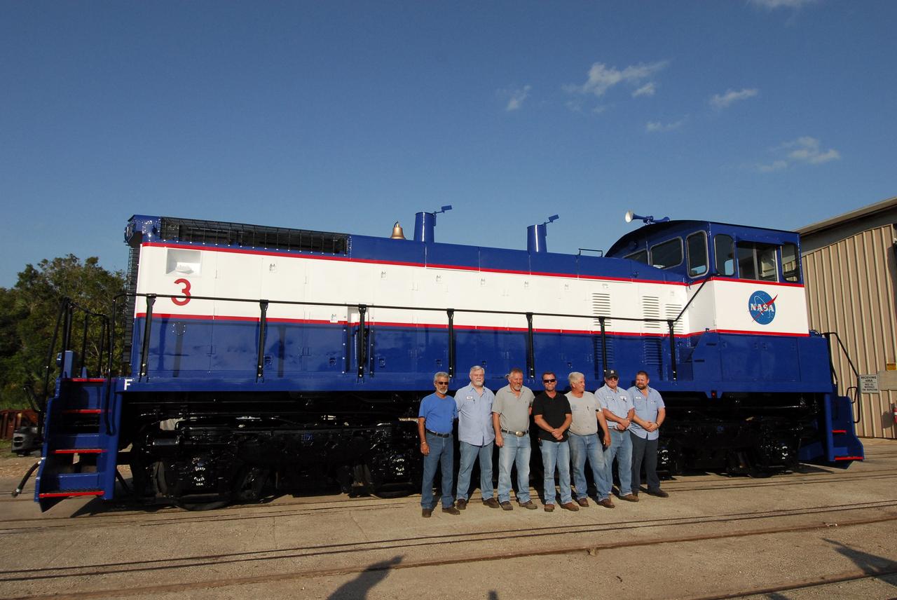 CAPE CANAVERAL, Fla. – At NASA's Kennedy Space Center in Florida, the NASA Railroad Maintenance Crew poses alongside NASA Railroad locomotive 3. From left are Rick Koury, Will Eriksen, Mike Stephens, Chris Bryant, Gary Steele, Jesse Crews and Mike Fitch. The team at Kennedy completed the refurbishment of locomotive 3 in October. The 15-month process, including a new paint scheme, dealt with extensive corrosion to the locomotive because of Kennedy's proximity to the Atlantic Ocean. Locomotives 1 and 2 also will be refurbished eventually. The NASA Railroad locomotives are SW-1500 switch engines built by Electro Motive Diesel (EMD). Photo credit: NASA/Amanda Diller