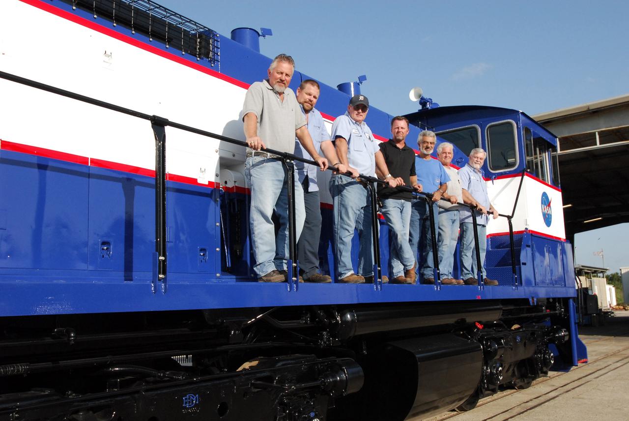 CAPE CANAVERAL, Fla. – At NASA's Kennedy Space Center in Florida, the NASA Railroad Maintenance Crew pose on the side of NASA Railroad locomotive 3. From left are Mike Stephens, Mike Fitch, Jesse Crews, Chris Bryant, Rick Koury, Gary Steele and Will Eriksen. The team at Kennedy completed the refurbishment of locomotive 3 in October. The 15-month process, including a new paint scheme, dealt with extensive corrosion to the locomotive because of Kennedy's proximity to the Atlantic Ocean. Locomotives 1 and 2 also will be refurbished eventually. The NASA Railroad locomotives are SW-1500 switch engines built by Electro Motive Diesel (EMD). Photo credit: NASA/Amanda Diller