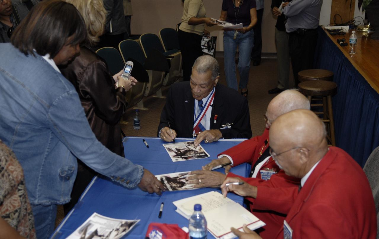 CAPE CANAVERAL, Fla. –    Retired U.S. Air Force Lt. Col. Lee A. Archer Jr. (seated at center), one of the Tuskegee Airmen, autographs photos for guests after a special presentation to the  work force at NASA's Kennedy Space Center in Florida.  Archer shared his experiences as combat fighter pilot, civil rights leader and business executive. Archer is the only Tuskegee Airmen fighter pilot to receive the honor “Ace” for shooting down five enemy aircraft during WWII. He retired as Air Force Command Pilot after 30 years of military service, 1941-1971. Archer is at Kennedy to serve as Military Marshall of the 2008 KSC Space & Air Show, Nov. 8-9. Photo credit: NASA/Kim Shiflett