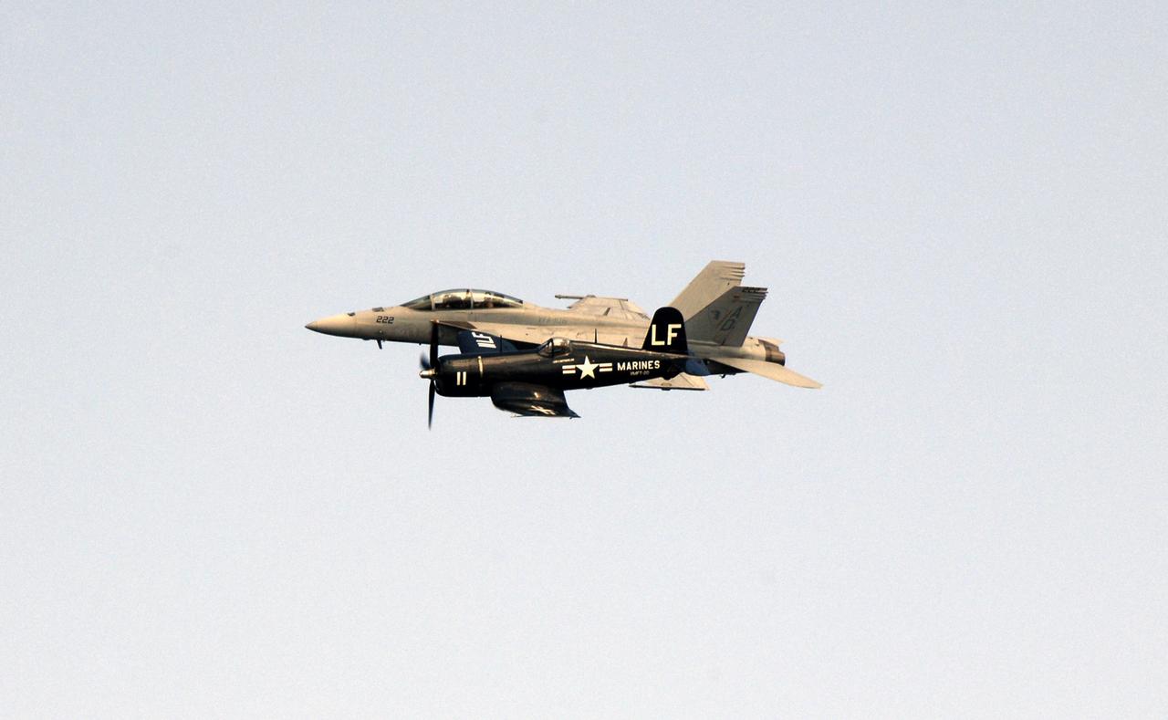 CAPE CANAVERAL, Fla. –    A contrast in speed and design, the F/A-18 Super Hornet jet (behind) flies alongside a World War II Vought F4U Corsair during the Kennedy Space Center Visitor Complex Space and Air Show Nov. 8-9 at NASA's Kennedy Space Center in Florida. This year’s show brought together the best in military aircraft, such as the F/A-18 Super Hornet and F-16 Fighting Falcon, coupled with precision pilots and veteran astronauts to celebrate spaceflight and aviation. The event included a water rescue demonstration by the 920th Rescue Wing.  Photo credit: NASA/Kim Shiflett