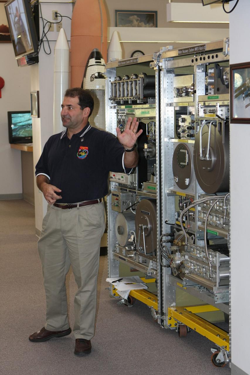 CAPE CANAVERAL, Fla. –  In the News Center at NASA's Kennedy Space Center in Florida, Bob Bagdigian talks to the media about the Water Recovery System being delivered to the International Space Station on space shuttle Endeavour's STS-126 mission. Bagdigian is a project manager with NASA's Regenerative Environmental Control and Life Support System at Marshall Space Flight Center in Huntsville, Ala.  Behind Bagdigian is a mockup of the two racks that will be used.  The two units of the Water Recovery System are designed to provide drinking-quality water through the reclamation of wastewater, including urine and hygiene wastes. The water that’s produced will be used to support the crew and work aboard the station.  STS-126 is the 124th space shuttle flight and the 27th flight to the International Space Station. The mission will feature four spacewalks and work that will prepare the space station to house six crew members for long- duration missions.  Liftoff is scheduled for 7:55 p.m. EST Nov. 14.   Photo credit: NASA/Dimitri Gerondidakis
