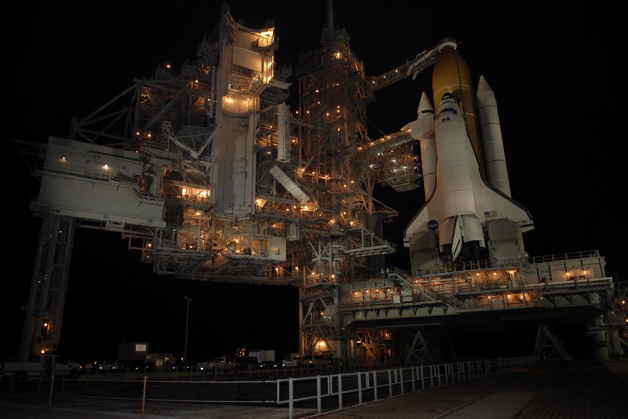 CAPE CANAVERAL, Fla. – Lighted against the black of night, space shuttle Endeavour is revealed after rollback of the rotating service structure. The rollback is in preparation for liftoff on the STS-126 mission with a crew of seven. Above Endeavour's external tank is the vent hood, known as the "beanie cap," at the end of the gaseous oxygen vent arm, extending from the fixed service structure. Vapors are created as the liquid oxygen in the external tank boil off. The hood vents the gaseous oxygen vapors away from the space shuttle vehicle. Below is the orbiter access arm with the White Room at the end, flush against the shuttle. The rotating structure provides protected access to the shuttle for changeout and servicing of payloads at the pad. It is supported by a rotating bridge that pivots on a vertical axis on the west side of the pad's flame trench. After the RSS is rolled back, the orbiter is ready for fuel cell activation and external tank cryogenic propellant loading operations. The STS-126 mission will be the 124th space shuttle flight and the 27th flight to the International Space Station. The mission will feature four spacewalks and work that will prepare the space station to house six crew members for long- duration missions. Liftoff is scheduled for 7:55 p.m. EST Nov. 14. Photo credit: NASA/Kim Shiflett