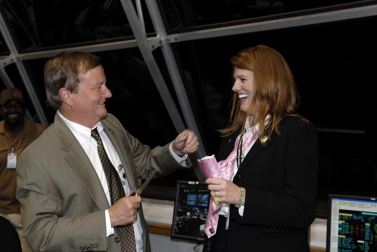 CAPE CANAVERAL, Fla. – In the Firing Room of the Launch Control Center at NASA's Kennedy Space Center in Florida, Shuttle Launch Director Mike Leinbach (left) congratulates STS-126 NASA Test Director Charlie Blackwell-Thompson with the traditional tie-cutting ceremony for a first-time NTD. Congratulations were offered for the successful launch of space shuttle Endeavour. Liftoff was on time at 7:55 p.m. EST. STS-126 is the 124th space shuttle flight and the 27th flight to the International Space Station. The mission will feature four spacewalks and work that will prepare the space station to house six crew members for long-duration missions. Photo credit: NASA/Kim Shiflett