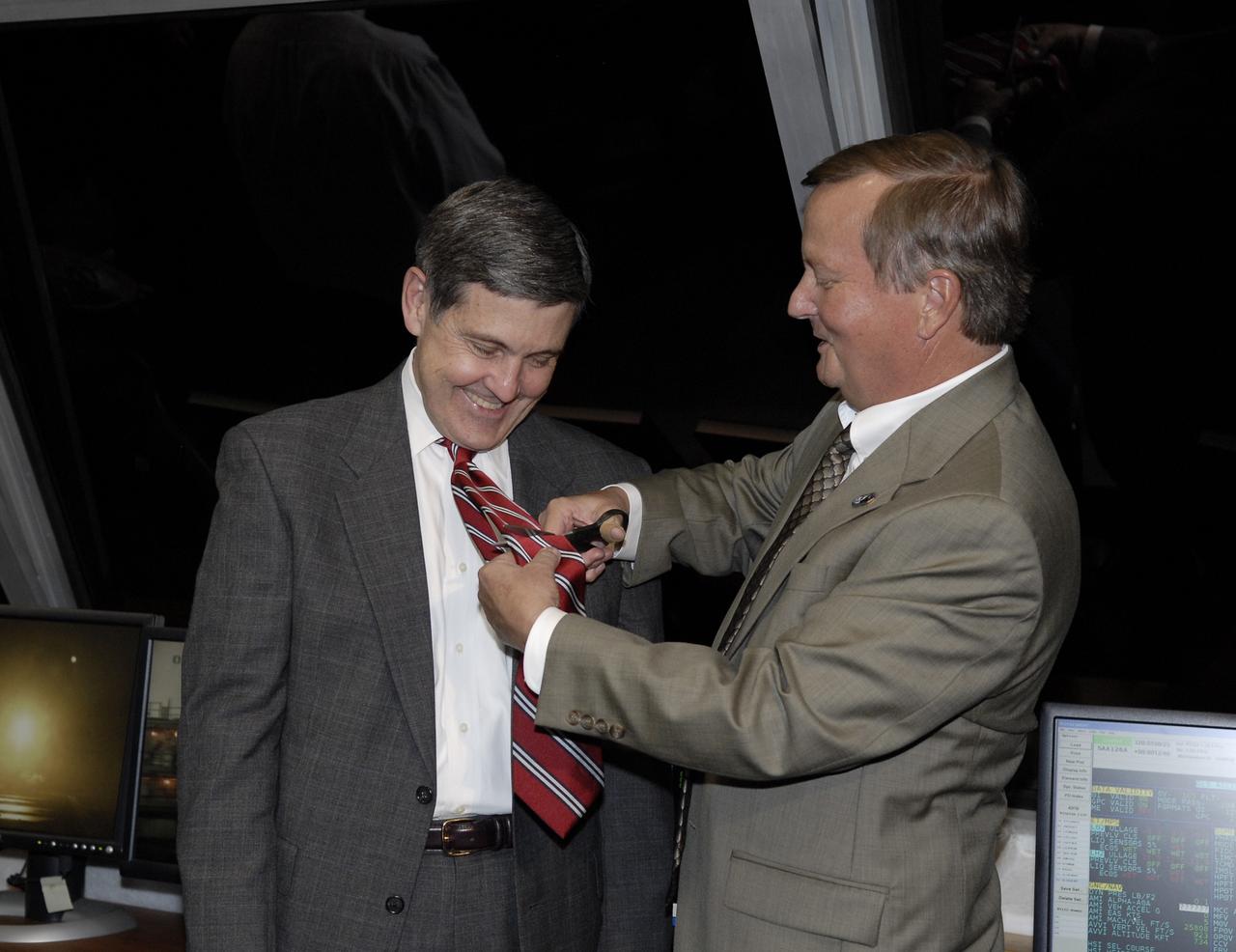 CAPE CANAVERAL, Fla. – After the successful launch of space shuttle Endeavour on the STS-126 mission at NASA's Kennedy Space Center in Florida, Shuttle Launch Director Mike Leinbach (right) performs the tie-cutting ceremony on Center Director Bob Cabana in the Firing Room of the Launch Control Center.  Cabana experienced his first shuttle launch as director. Liftoff was on time at 7:55 p.m. EST. STS-126 is the 124th space shuttle flight and the 27th flight to the International Space Station. The mission will feature four spacewalks and work that will prepare the space station to house six crew members for long-duration missions.  Photo credit: NASA/Kim Shiflett