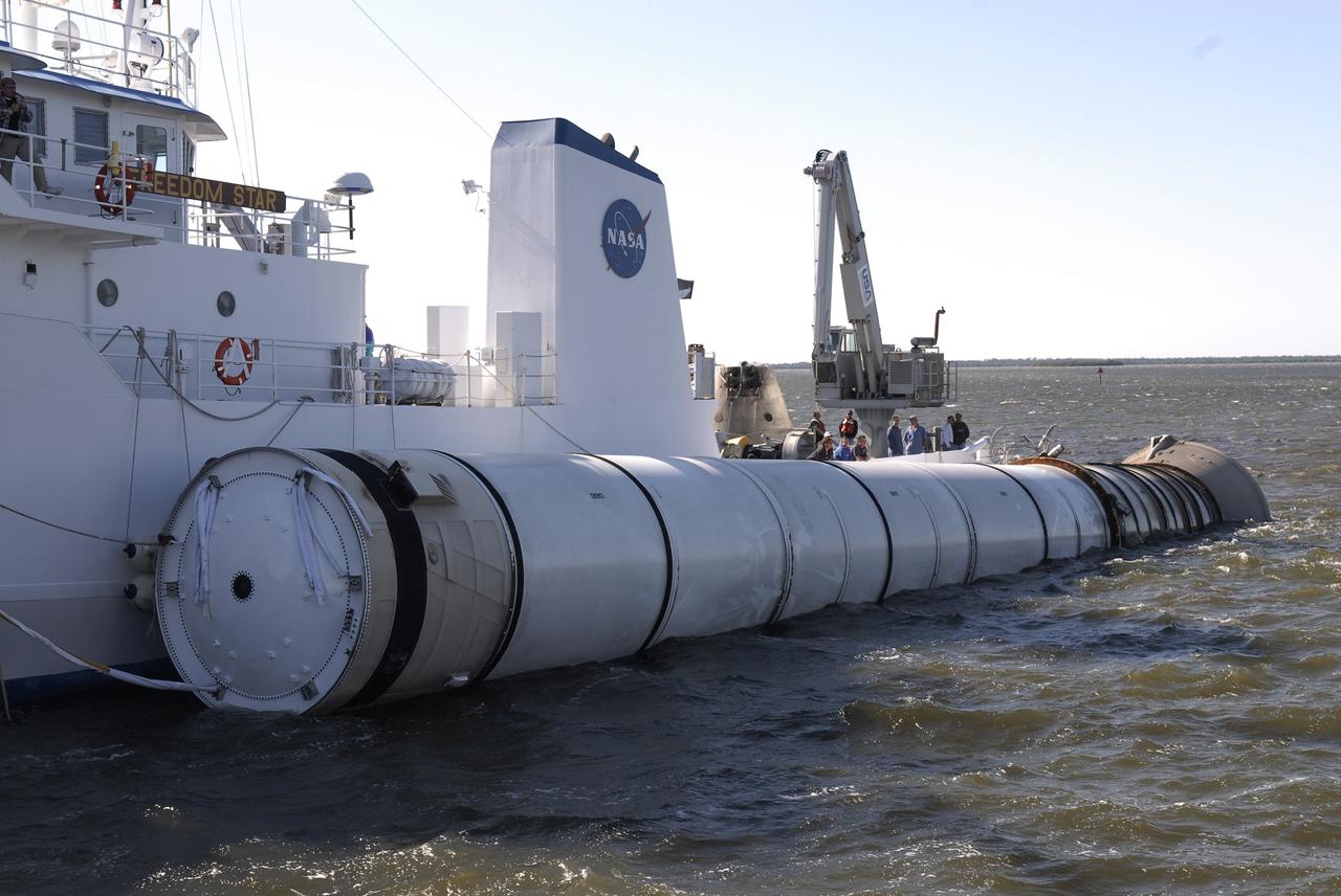 CAPE CANAVERAL, Fla. –   NASA's Solid Rocket Booster Retrieval Ship Freedom Star tows along its side one of the spent booster rockets from the space shuttle Endeavour launch Nov. 14 on the STS-126 mission.  The ship is returning the spent rocket to Hangar AF at Cape Canaveral Air Force Station in Florida. The space shuttle’s solid rocket booster casings and associated flight hardware are recovered at sea. The boosters impact the Atlantic Ocean approximately seven minutes after liftoff. The splashdown area is a square of about six by nine nautical miles located about 140 nautical miles downrange from the launch pad. The retrieval ships are stationed approximately 8 to 10 nautical miles from the impact area at the time of splashdown. As soon as the boosters enter the water, the ships accelerate to a speed of 15 knots and quickly close on the boosters. The pilot chutes and main parachutes are the first items to be brought on board. With the chutes and frustum recovered, attention turns to the boosters. The ship’s tow line is connected and the booster is returned to the Port and, after transfer to a position alongside the ship, to Hangar AF. There, the expended boosters are disassembled, refurbished and reloaded with solid propellant for reuse. Photo credit: NASA/Kim Shiflett