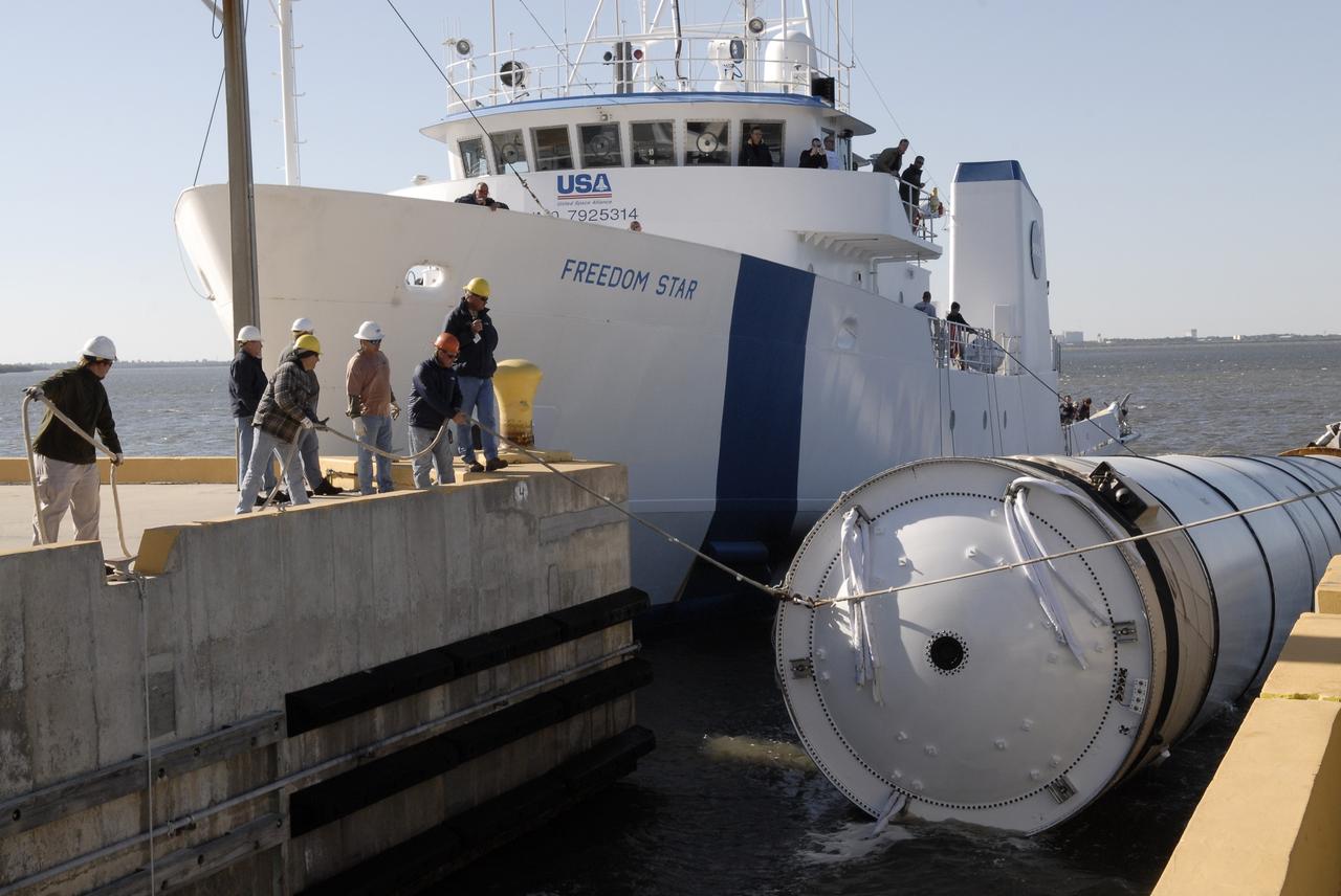 CAPE CANAVERAL, Fla. –   NASA's Solid Rocket Booster Retrieval Ship Freedom Star arrives at the dock at Hangar AF, Cape Canaveral Air Force Station in Florida, with a spent solid rocket booster alongside.  The booster is from space shuttle Endeavour's launch Nov. 14 on mission STS-126. The space shuttle’s solid rocket booster casings and associated flight hardware are recovered at sea. The boosters impact the Atlantic Ocean approximately seven minutes after liftoff. The splashdown area is a square of about six by nine nautical miles located about 140 nautical miles downrange from the launch pad. The retrieval ships are stationed approximately 8 to 10 nautical miles from the impact area at the time of splashdown. As soon as the boosters enter the water, the ships accelerate to a speed of 15 knots and quickly close on the boosters. The pilot chutes and main parachutes are the first items to be brought on board. With the chutes and frustum recovered, attention turns to the boosters. The ship’s tow line is connected and the booster is returned to the Port and, after transfer to a position alongside the ship, to Hangar AF. There, the expended boosters are disassembled, refurbished and reloaded with solid propellant for reuse. Photo credit: NASA/Kim Shiflett