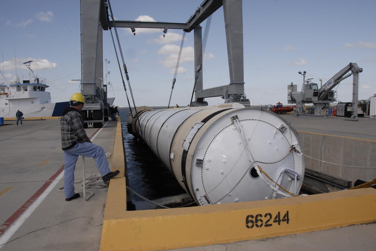 CAPE CANAVERAL, Fla. –   At the dock at Hangar AF at Cape Canaveral Air Force Station in Florida, workers move the spent solid rocket booster to an area beneath the straddle crane that will lift it out of the water. The booster is from space shuttle Endeavour, which launched Nov. 14 on the STS-126 mission. The space shuttle’s solid rocket booster casings and associated flight hardware are recovered at sea. The spent rocket was recovered by NASA's Solid Rocket Booster Retrieval Ship Freedom Star. The boosters impact the Atlantic Ocean approximately seven minutes after liftoff. The splashdown area is a square of about six by nine nautical miles located about 140 nautical miles downrange from the launch pad. The retrieval ships are stationed approximately 8 to 10 nautical miles from the impact area at the time of splashdown. As soon as the boosters enter the water, the ships accelerate to a speed of 15 knots and quickly close on the boosters. The pilot chutes and main parachutes are the first items to be brought on board. With the chutes and frustum recovered, attention turns to the boosters. The ship’s tow line is connected and the booster is returned to the Port and, after transfer to a position alongside the ship, to Hangar AF. There, the expended boosters are disassembled, refurbished and reloaded with solid propellant for reuse. Photo credit: NASA/Kim Shiflett
