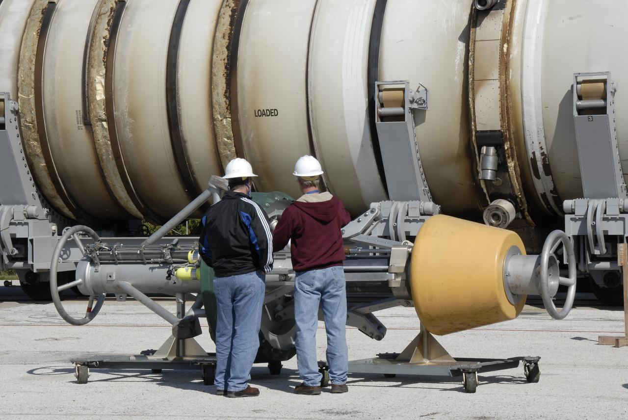 CAPE CANAVERAL, Fla. –  At the dock at Hangar AF at Cape Canaveral Air Force Station in Florida, workers prepare to move the spent solid rocket booster to the hangar for the safing process.  It will be driven through the washing bay for a cleaning and rinsing. The booster is from space shuttle Endeavour, which launched Nov. 14 on the STS-126 mission. The space shuttle’s solid rocket booster casings and associated flight hardware are recovered at sea. The boosters impact the Atlantic Ocean approximately seven minutes after liftoff. The splashdown area is a square of about six by nine nautical miles located about 140 nautical miles downrange from the launch pad. The retrieval ships are stationed approximately 8 to 10 nautical miles from the impact area at the time of splashdown. As soon as the boosters enter the water, the ships accelerate to a speed of 15 knots and quickly close on the boosters. The pilot chutes and main parachutes are the first items to be brought on board. With the chutes and frustum recovered, attention turns to the boosters. The ship’s tow line is connected and the booster is returned to the Port and, after transfer to a position alongside the ship, to Hangar AF. There, the expended boosters are disassembled, refurbished and reloaded with solid propellant for reuse. Photo credit: NASA/Kim Shiflett