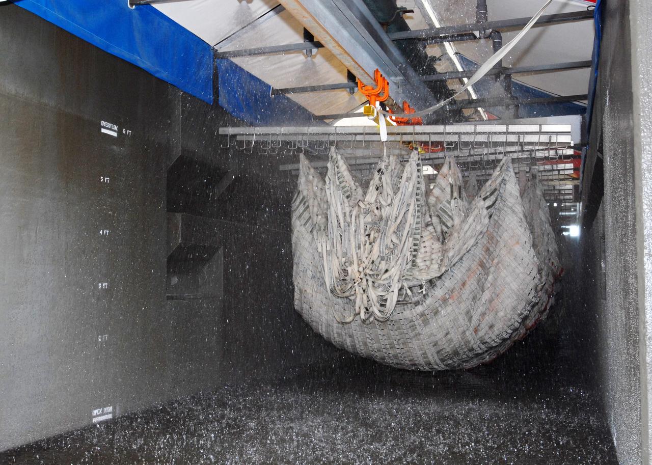 CAPE CANAVERAL, Fla. – At the Parachute Refurbishment Facility at NASA's Kennedy Space Center in Florida, the parachutes recovered from sea after the launch of space shuttle Endeavour on the STS-126 mission are moved through the 30,000-gallon washer. The parachutes are used to slow the descent of the solid rocket boosters that are jettisoned during liftoff. After washing, the monorail will move the parachutes into a huge dryer heated with 140-degree air at 13,000 cubic feet per minute. One pilot, one drogue and three main canopies per booster slow the booster’s fall from about 360 mph to 50 mph. After the chutes are cleaned and repaired, they must be carefully packed into their bags so they will deploy correctly the next time they are used. Photo credit: NASA/Jim Grossmann