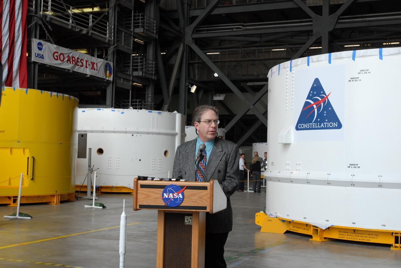 CAPE CANAVERAL, Fla. – Vince Bilardo, project manager from Glenn Research Center, talks to the media about the arrival of the Ares I-X upper stage simulator components behind him in the Vehicle Assembly Building's high bay 4 at NASA's Kennedy Space Center in Florida. The upper stage simulators will be used in the test flight identified as Ares I-X in 2009. The segments will simulate the mass and the outer mold line and will be more than 100 feet of the total vehicle height of 327 feet. The simulator comprises 11 segments that are approximately 18 feet in diameter. Most of the segments will be approximately 10 feet high, ranging in weight from 18,000 to 60,000 pounds, for a total of approximately 450,000 pounds. Photo credit: NASA/Jim Grossmann