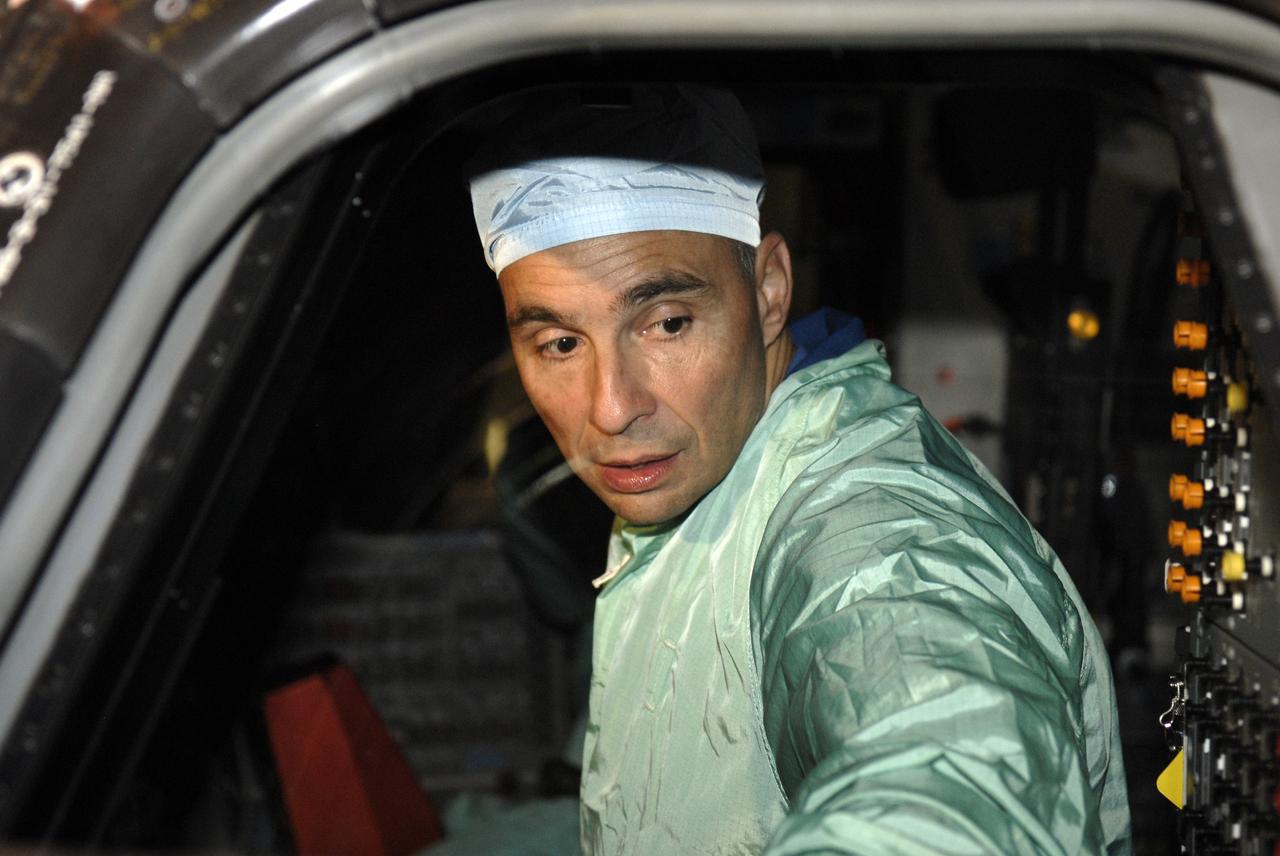 CAPE CANAVERAL, Fla. -- In the Orbiter Processing Facility at NASA's Kennedy Space Center in Florida, STS-119 Commander Lee Archambault checks the cockpit window of space shuttle Discovery.  He and other crew members are at Kennedy for a Crew Equipment Interface Test that provides experience handling tools, equipment and hardware they will use on the mission. On the STS-119 mission, space shuttle Discovery will carry the S6 truss segment to complete the 361-foot-long backbone of the International Space Station. The truss includes the fourth pair of solar array wings and electronics that convert sunlight to power for the orbiting laboratory.  Discovery is targeted for launch on Feb. 12, 2009. Photo credit: NASA/Kim Shiflett