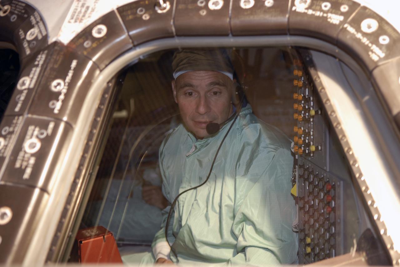 CAPE CANAVERAL, Fla. -- In the Orbiter Processing Facility at NASA's Kennedy Space Center in Florida, STS-119 Commander Lee Archambault checks the cockpit window of space shuttle Discovery. He and other crew members are at Kennedy for a Crew Equipment Interface Test that provides experience handling tools, equipment and hardware they will use on the mission. On the STS-119 mission, space shuttle Discovery will carry the S6 truss segment to complete the 361-foot-long backbone of the International Space Station. The truss includes the fourth pair of solar array wings and electronics that convert sunlight to power for the orbiting laboratory. Discovery is targeted for launch on Feb. 12, 2009. Photo credit: NASA/Kim Shiflett