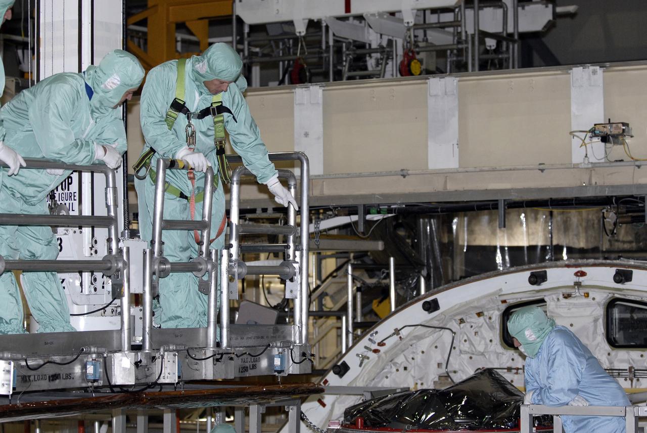 CAPE CANAVERAL, Fla. -- In the Orbiter Processing Facility at NASA's Kennedy Space Center in Florida, STS-119 crew members go inside space shuttle Discovery's payload bay for a close look at hardware. The crew is at Kennedy for a Crew Equipment Interface Test that provides experience handling tools, equipment and hardware they will use on the mission. On the STS-119 mission, space shuttle Discovery will carry the S6 truss segment to complete the 361-foot-long backbone of the International Space Station. The truss includes the fourth pair of solar array wings and electronics that convert sunlight to power for the orbiting laboratory. Discovery is targeted for launch on Feb. 12, 2009. Photo credit: NASA/Kim Shiflett