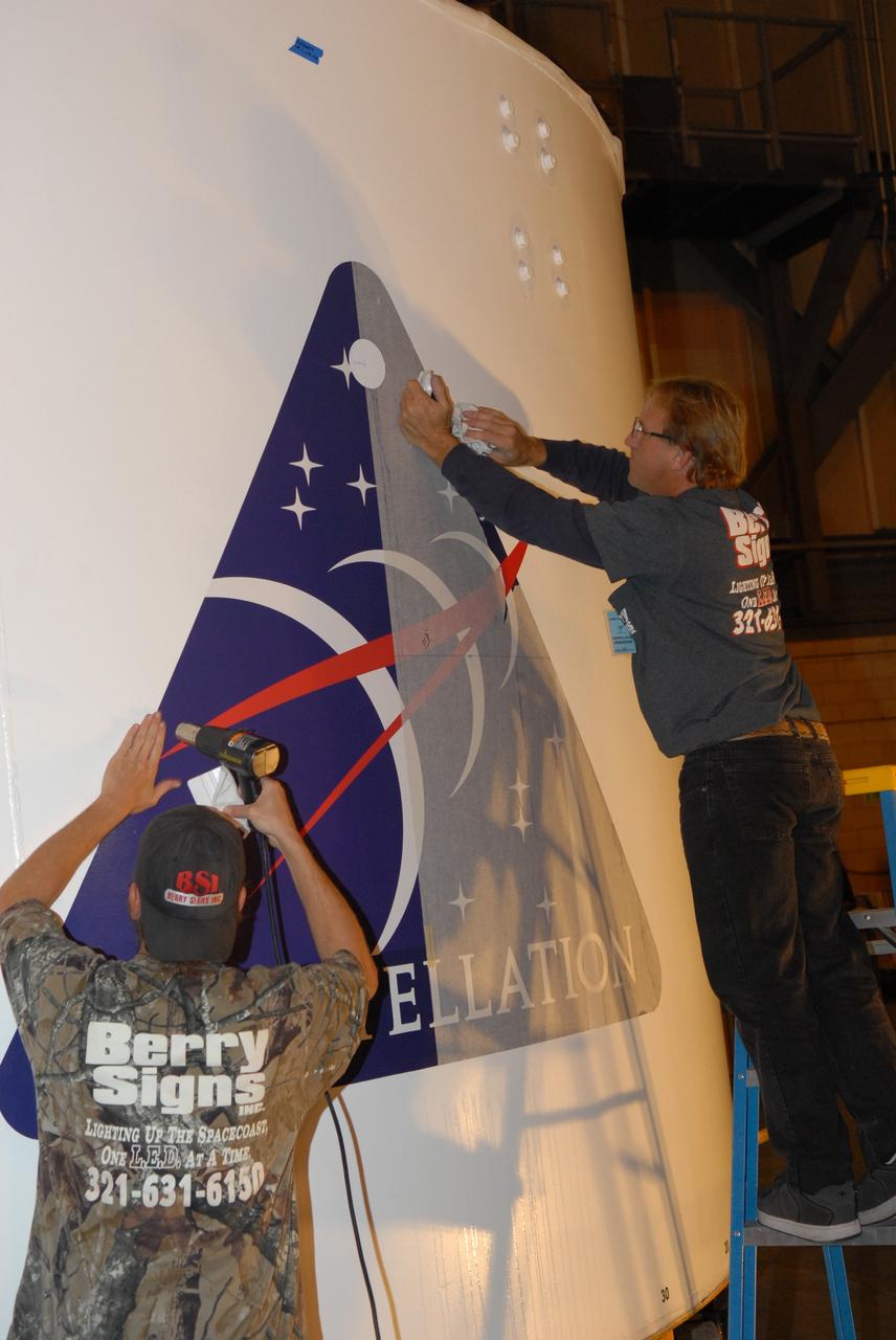 CAPE CANAVERAL, Fla. –  In the Vehicle Assembly Building high bay 4 at NASA's Kennedy Space Center in Florida, workers begin adhering the Constellation patch on one of the Ares I-X upper stage simulator segments. The upper stage simulator will be used in the test flight identified as Ares I-X in 2009.  Ares I-X is the test vehicle for the Ares I, which is part of the Constellation Program to return men to the moon and beyond.  Ares I is the essential core of a safe, reliable, cost-effective space transportation system that eventually will carry crewed missions back to the moon, on to Mars and out into the solar system. Ares I may also use its 25-ton payload capacity to deliver resources and supplies to the International Space Station, or to "park" payloads in orbit for retrieval by other spacecraft bound for the moon or other destinations.  Photo credit: NASA/Jack Pfaller