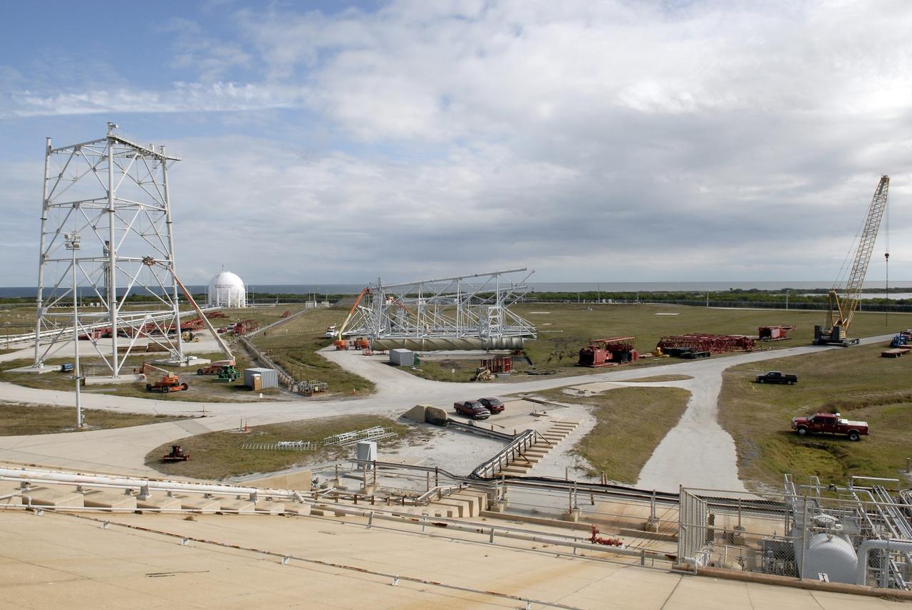 CAPE CANAVERAL, Fla. – On Launch Pad 39B at NASA's Kennedy Space Center in Florida, a giant crane (at right) is under construction to help finish erecting the lightning towers (at left) on the pad. The crane segments arrived on 125 trucks. Lightning towers are being constructed to hold catenary wires as part of the new lightning protection system for the Constellation Program and Ares/Orion launches. Photo credit: NASA/Kim Shiflett