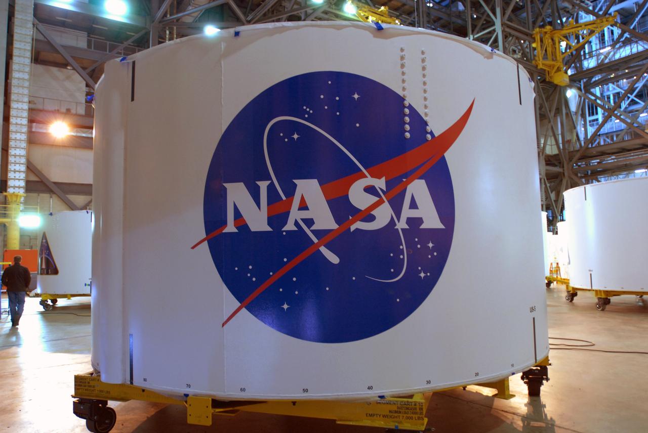 CAPE CANAVERAL, Fla. – In the Vehicle Assembly Building high bay 4 at NASA's Kennedy Space Center in Florida, one of the Ares I-X upper stage simulator segments bears the decal of the NASA insignia. The upper stage simulator will be used in the test flight identified as Ares I-X in 2009.  Ares I is the essential core of a safe, reliable, cost-effective space transportation system that eventually will carry crewed missions back to the moon, on to Mars and out into the solar system. Ares I may also use its 25-ton payload capacity to deliver resources and supplies to the International Space Station, or to "park" payloads in orbit for retrieval by other spacecraft bound for the moon or other destinations.    Photo credit: NASA/Jim Grossmann