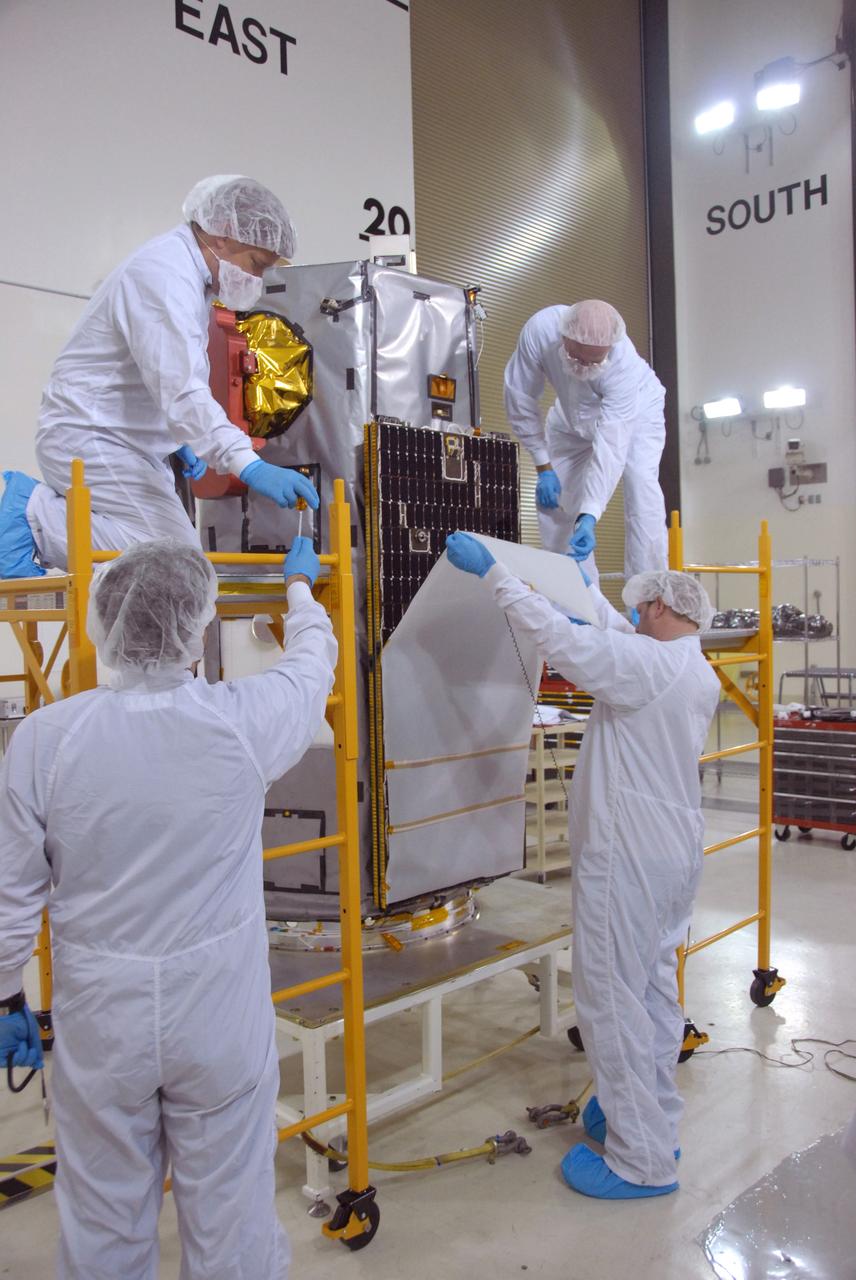 VANDENBERG AIR FORCE BASE, Calif. -- Inside the Astrotech payload processing facility, building 1032, at Vandenberg Air Force Base in California, workers remove the wrapping from around the Orbiting Carbon Observatory, or OCO. After the protective coverings over the spacecraft are removed, blanket preparations and edge taping will be done, followed by mechanical preparations and work on the electronic ground support equipment. The OCO is a new Earth-orbiting mission sponsored by NASA's Earth System Science Pathfinder Program. The observatory is targeted to launch Jan. 15 from Space Launch Complex 576-E at Vandenberg. Photo credit: NASA/Robert Hargreaves Jr., VAFB