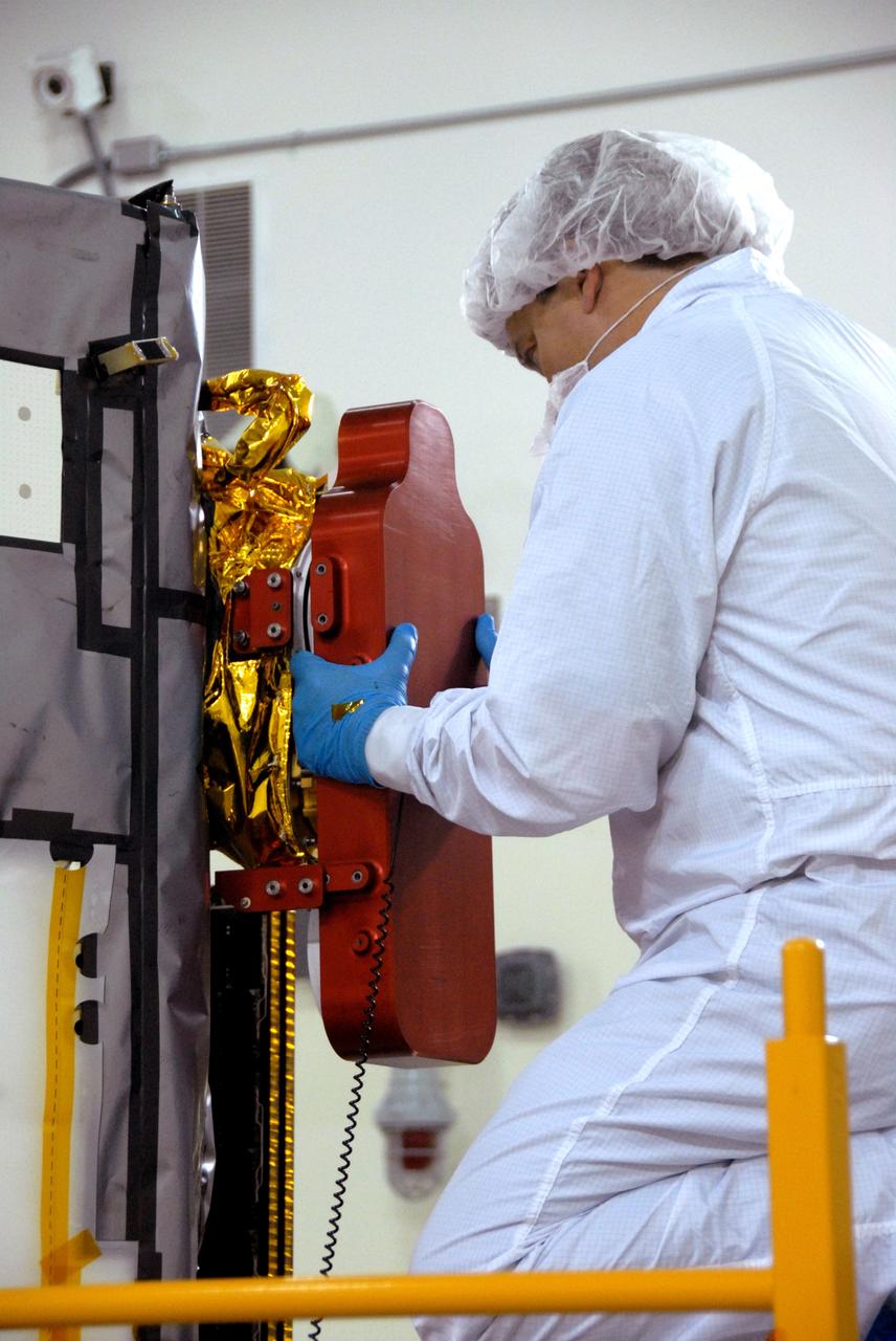 VANDENBERG AIR FORCE BASE, Calif. -- Inside the Astrotech payload processing facility, building 1032, at Vandenberg Air Force Base in California, workers check the Orbiting Carbon Observatory, or OCO. After the protective coverings over the spacecraft are removed, blanket preparations and edge taping will be done, followed by mechanical preparations and work on the electronic ground support equipment. The OCO is a new Earth-orbiting mission sponsored by NASA's Earth System Science Pathfinder Program. The observatory is targeted to launch Jan. 15 from Space Launch Complex 576-E at Vandenberg. Photo credit: NASA/Robert Hargreaves Jr., VAFB