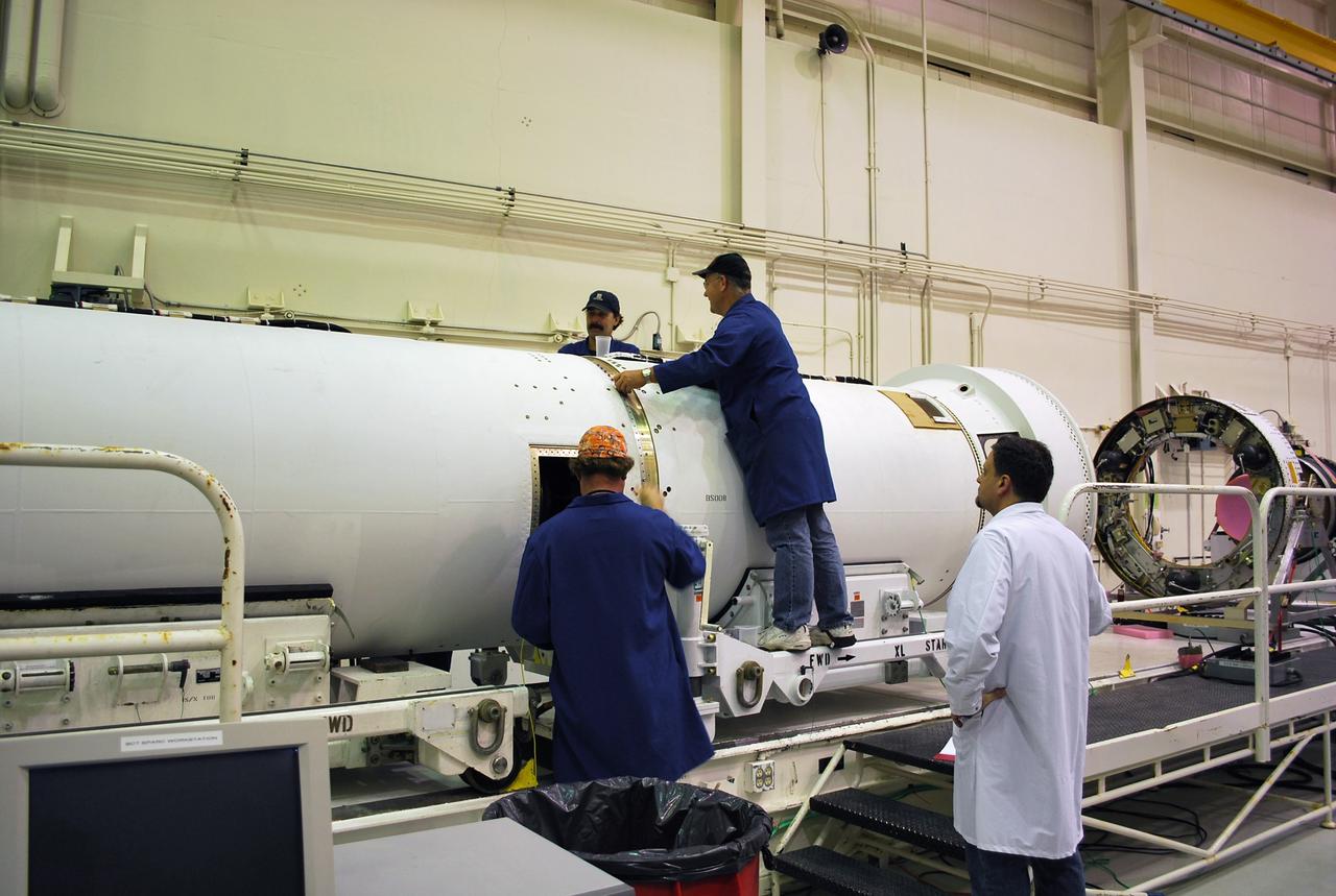 CAPE CANAVERAL, Fla. --  In Building 1555 at Vandenberg Air Force Base in California, workers do a fit check on the mating of the  Stage 1 to Stage 2 motors for the Taurus XL rocket that will launch NASA's Orbiting Carbon Observatory, or OCO, spacecraft. At right can be seen the avionics shelf.  The avionics skirt, a graphite/epoxy structure, supports the avionics shelf and carries the primary structural loads from the fairing and payload cone. The aluminum avionics shelf supports the third stage avionics.  The OCO is a new Earth-orbiting mission sponsored by NASA's Earth System Science Pathfinder Program. The launch of OCO is targeted for January.  Photo credit: NASA/Randy Beaudoin, VAFB