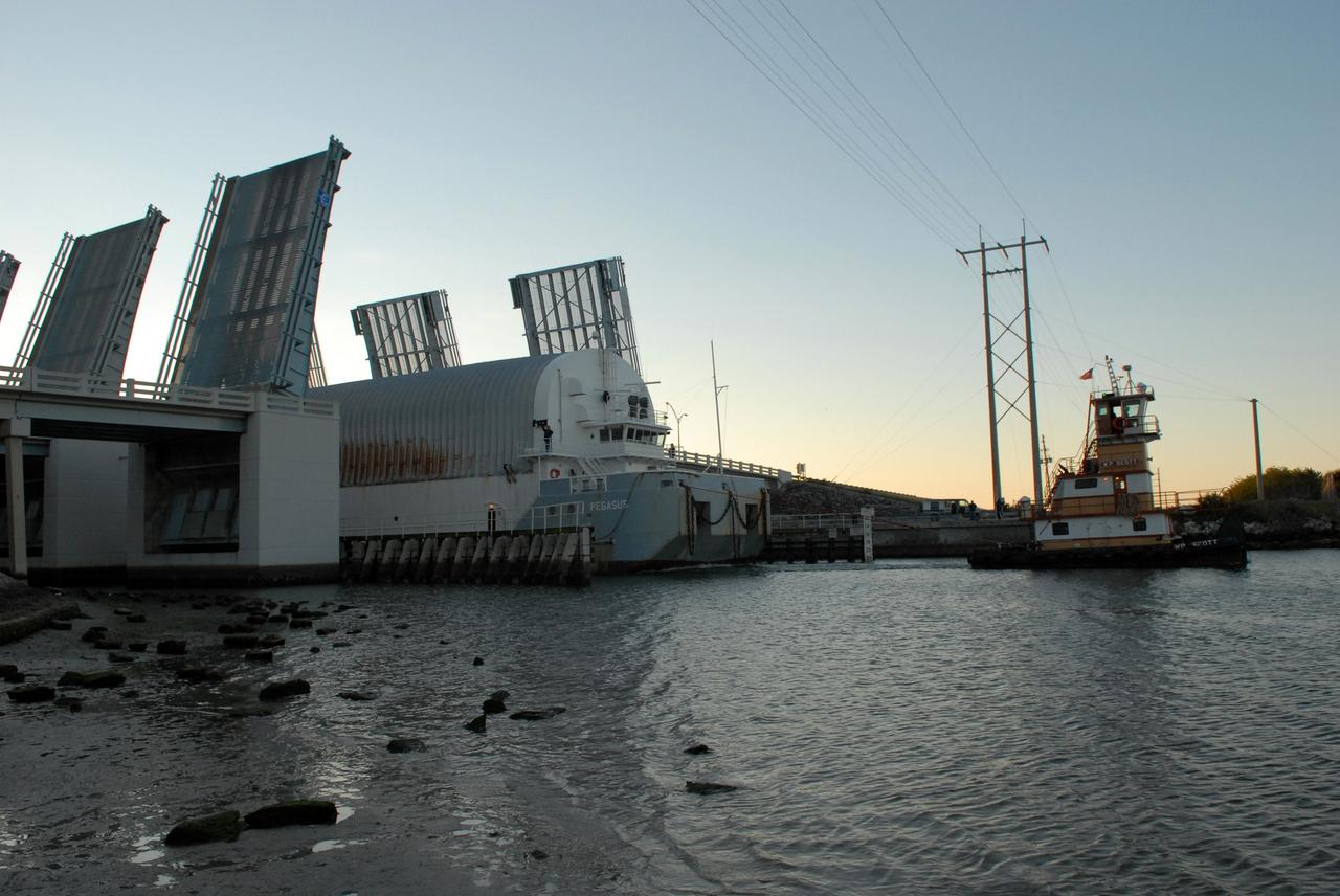 CAPE CANAVERAL, Fla. -- The Pegasus barge carrying external tank 130 moves through the Banana River bridge in Florida after an ocean voyage towed by a solid rocket booster retrieval ship from NASA's Michoud Assembly Facility near New Orleans. Pegasus will continue upriver to the turn basin near the Vehicle Assembly Building, or VAB, at NASA's Kennedy Space Center in Florida. After the Pegasus docks, the fuel tank will be offloaded and transported to the VAB. External tank 130 is the one designated for space shuttle Endeavour on the STS-127 mission targeted for launch on May 15. Photo credit: NASA/Troy Cryder