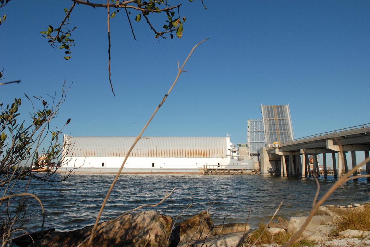 CAPE CANAVERAL, Fla. -- The Pegasus barge carrying external tank 130 moves through the Banana River bridge in Florida after an ocean voyage towed by a solid rocket booster retrieval ship from NASA's Michoud Assembly Facility near New Orleans. Pegasus will continue upriver to the turn basin near the Vehicle Assembly Building, or VAB, at NASA's Kennedy Space Center in Florida. After the Pegasus docks, the fuel tank will be offloaded and transported to the VAB. External tank 130 is the one designated for space shuttle Endeavour on the STS-127 mission targeted for launch on May 15. Photo credit: NASA/Troy Cryder