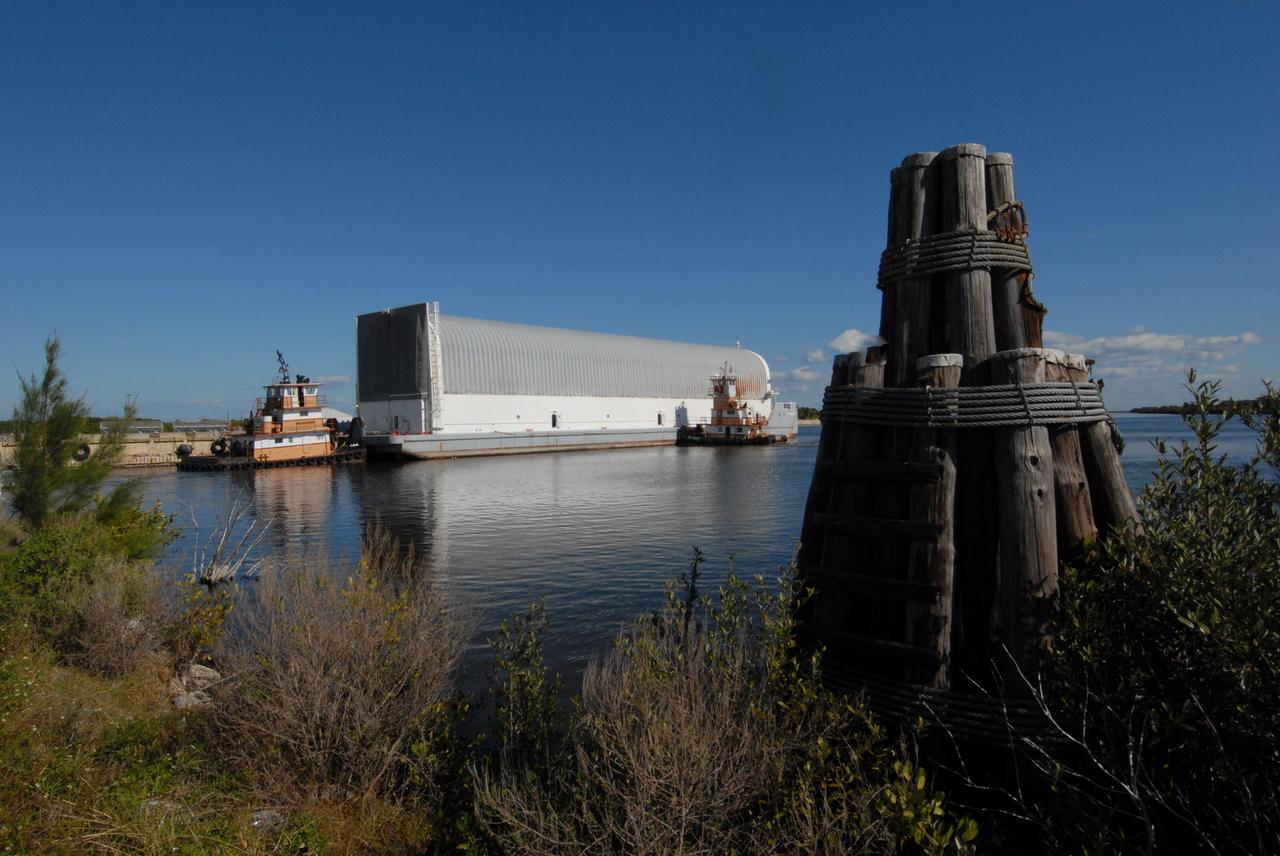 CAPE CANAVERAL, Fla. -- Towed by tugboats, the Pegasus barge with its cargo of external tank 130 nears the dock in the turn basis near the Vehicle Assembly Building, or VAB, at NASA's Kennedy Space Center in Florida. Pegasus arrived in Florida after an ocean voyage towed by a solid rocket booster retrieval ship from NASA's Michoud Assembly Facility near New Orleans. After the Pegasus docks, the fuel tank will be offloaded and transported to the VAB. External tank 130 is the one designated for space shuttle Endeavour on the STS-127 mission targeted for launch on May 15. Photo credit: NASA/Troy Cryder
