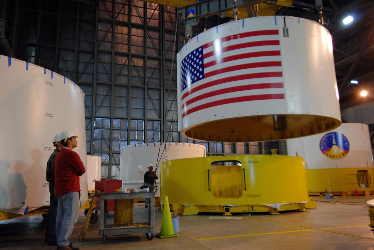 CAPE CANAVERAL, Fla. --  Inside the Vehicle Assembly Building's high bay 4 at NASA's Kennedy Space Center in Florida, Ares I-X upper stage simulator segment 6 is lifted off the floor to be moved to a stand. The upper stage simulator comprises 11 segments, each approximately 18 feet in diameter, that will be used in the test flight identified as Ares I-X in 2009.  The test flight will provide NASA an early opportunity to test and prove hardware, facilities and ground operations associated with the Ares I crew launch vehicle. The data will ensure the entire vehicle system is safe and fully operational before astronauts begin traveling to orbit.  The simulator segments will simulate the mass and the outer mold line and will be more than 100 feet of the total vehicle height of 327 feet.  Photo credit: NASA/Jack Pfaller