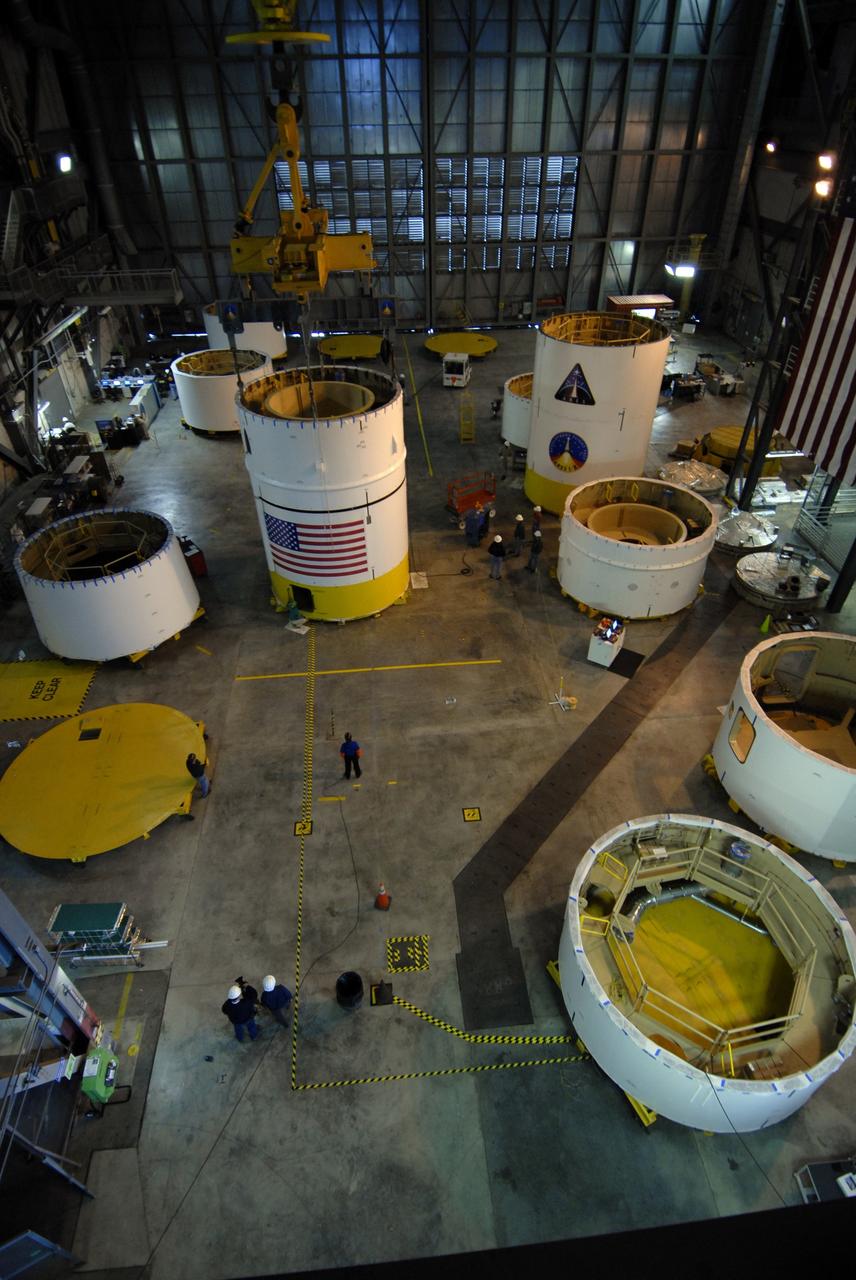 CAPE CANAVERAL, Fla. --  The upper stage simulator segments are positioned across the floor of the Vehicle Assembly Building's high bay 4 at NASA's Kennedy Space Center in Florida.  Four of the segments are already stacked.  The upper stage simulator will be used in the test flight identified as Ares I-X in 2009.  Ares I-X is the test vehicle for the Ares I, which is part of the Constellation Program to return men to the moon and beyond.  Ares I is the essential core of a safe, reliable, cost-effective space transportation system that eventually will carry crewed missions back to the moon, on to Mars and out into the solar system. Ares I may also use its 25-ton payload capacity to deliver resources and supplies to the International Space Station, or to "park" payloads in orbit for retrieval by other spacecraft bound for the moon or other destinations. The upper stage simulator comprises 11 segments, each approximately 18 feet in diameter.  The simulator segments will simulate the mass and the outer mold line and will be more than 100 feet of the total vehicle height of 327 feet. Photo credit: NASA/Jack Pfaller