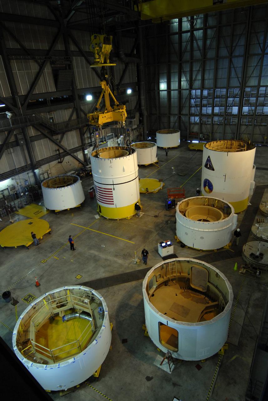 CAPE CANAVERAL, Fla. --  The upper stage simulator segments are positioned across the floor of the Vehicle Assembly Building's high bay 4 at NASA's Kennedy Space Center in Florida.  Four of the segments are already stacked.  The upper stage simulator will be used in the test flight identified as Ares I-X in 2009.  Ares I-X is the test vehicle for the Ares I, which is part of the Constellation Program to return men to the moon and beyond.  Ares I is the essential core of a safe, reliable, cost-effective space transportation system that eventually will carry crewed missions back to the moon, on to Mars and out into the solar system. Ares I may also use its 25-ton payload capacity to deliver resources and supplies to the International Space Station, or to "park" payloads in orbit for retrieval by other spacecraft bound for the moon or other destinations. The upper stage simulator comprises 11 segments, each approximately 18 feet in diameter.  The simulator segments will simulate the mass and the outer mold line and will be more than 100 feet of the total vehicle height of 327 feet. Photo credit: NASA/Jack Pfaller