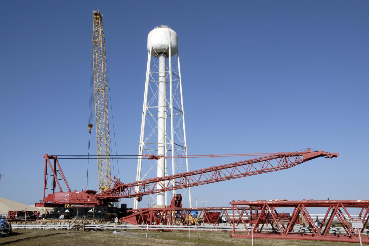 CAPE CANAVERAL, Fla. -- On Launch Pad 39B at NASA's Kennedy Space Center in Florida, segments are being added to the crane (foreground) that will be used to finish erecting the lightning towers on the pad. Lightning towers are being constructed to hold centenary wires as part of the new lightning protection system for the Constellation Program and Ares/Orion launches. Photo credit: NASA/Kim Shiflett