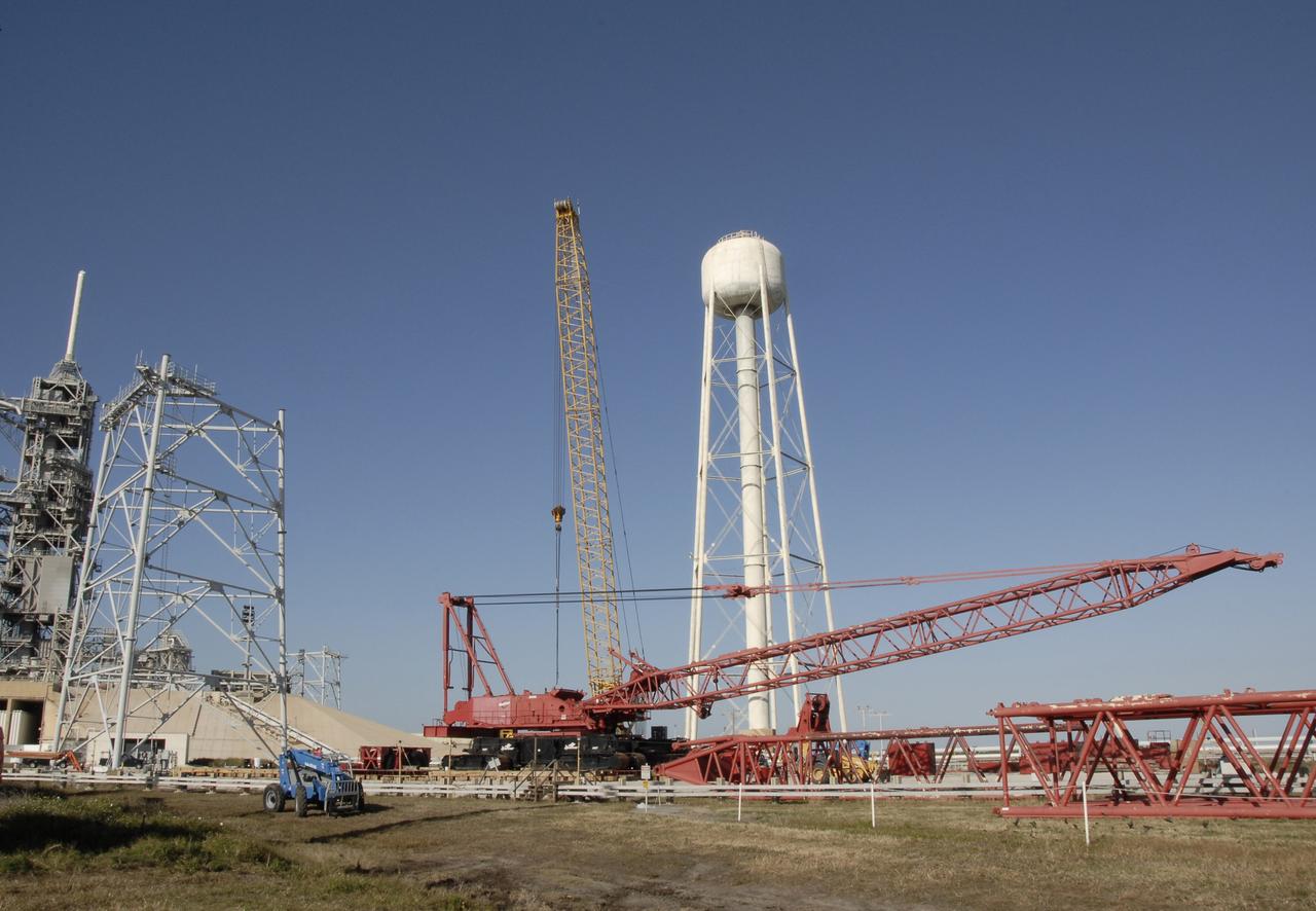 CAPE CANAVERAL, Fla. -- On Launch Pad 39B at NASA's Kennedy Space Center in Florida, segments are being added to the crane (foreground) that will be used to finish erecting the lightning towers (one is at left) on the pad. In the background is the 290-foot-high tower that holds 300,000 gallons of water used for sound suppression during shuttle launches. Lightning towers are being constructed to hold centenary wires as part of the new lightning protection system for the Constellation Program and Ares/Orion launches. Photo credit: NASA/Kim Shiflett