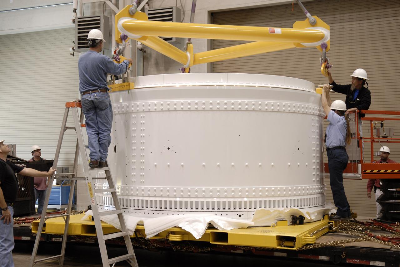 CAPE CANAVERAL, Fla. -- In the Assembly and Refurbishment Facility at NASA's Kennedy Space Center in Florida, the forward skirt extension of the Ares I-X first stage is lowered onto a work stand. The extension will house new, larger parachutes. The three main parachutes each have a 150-foot diameter, compared to the shuttle booster main parachutes, which are 136 feet across. Photo credit: NASA/Kim Shiflett