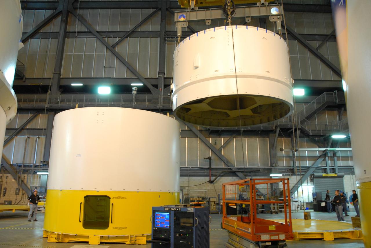 CAPE CANAVERAL, Fla. --  In high bay 4 of the Vehicle Assembly Building at NASA's Kennedy Space Center in Florida, a crane lifts the Ares I-X upper stage simulator segment 7.  The segment will be stacked onto segment 6. The upper stage simulator comprises 11 segments, each approximately 18 feet in diameter, that will be used in the test flight identified as Ares I-X in 2009.  The simulator segments will simulate the mass and the outer mold line.  The upper stage accounts for nearly one-quarter of the total height of the Ares I.  It will take the Ares I on the second phase of its journey from Earth, providing the guidance, navigation and control needed for the second phase of the Ares I ascent flight.  Photo credit: NASA/Kim Shiflett