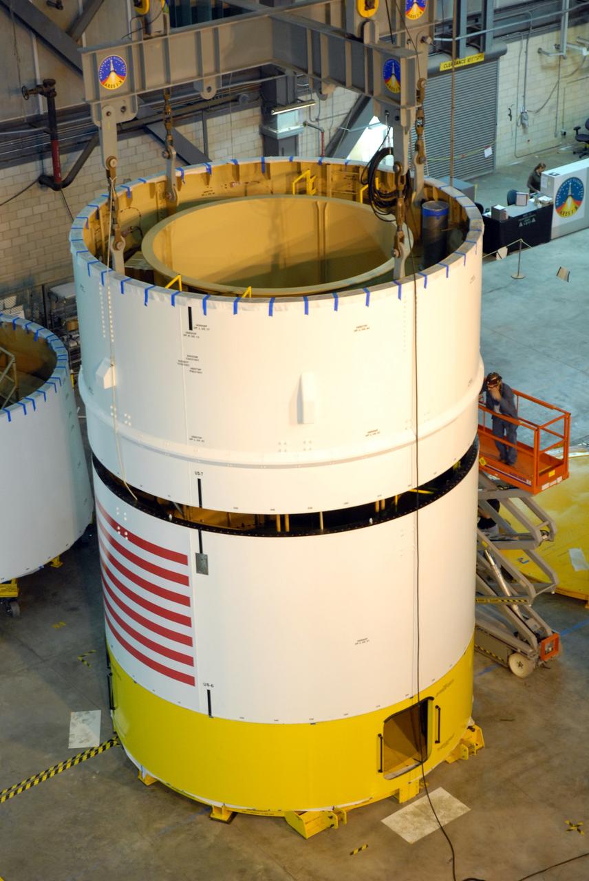 CAPE CANAVERAL, Fla. -- In high bay 4 of the Vehicle Assembly Building at NASA's Kennedy Space Center in Florida, a crane lowers the Ares I-X upper stage simulator segment 7 onto segment 6.  The upper stage simulator comprises 11 segments, each approximately 18 feet in diameter, that will be used in the test flight identified as Ares I-X in 2009.  The simulator segments will simulate the mass and the outer mold line.  The upper stage accounts for nearly one-quarter of the total height of the Ares I.  It will take the Ares I on the second phase of its journey from Earth, providing the guidance, navigation and control needed for the second phase of the Ares I ascent flight.  Photo credit: NASA/Kim Shiflett
